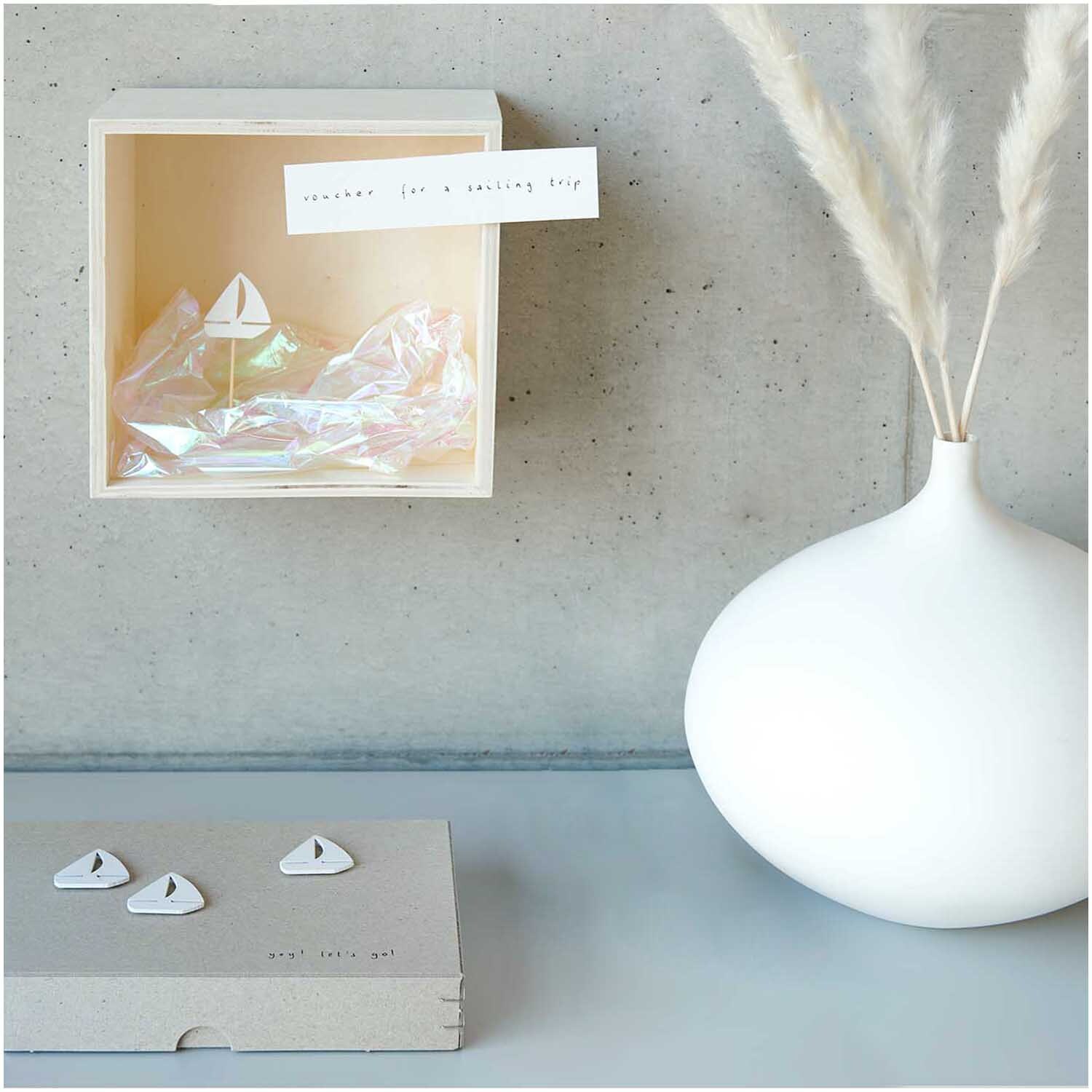 Autocollants en bois bateau à voile blanc 3x3cm 36 pièces from Rico Design Holzsticker Segelboot weiß 3x3cm 36 Stück, dekorativ in einer Box mit Vase und Pampasgras arrangiert.