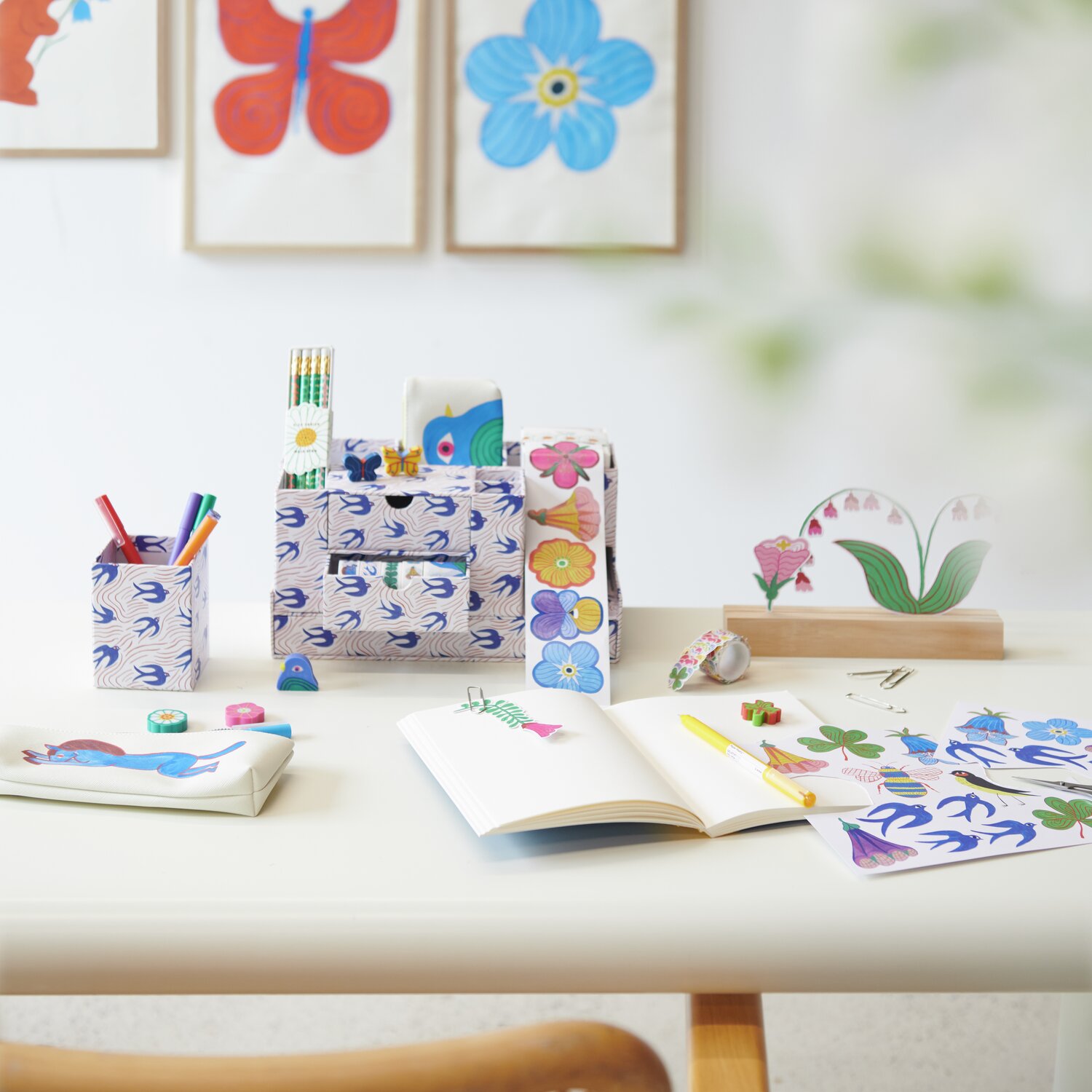 Office Box Midsommar Magic Schwalben 26x12,9x14,9cm von Rico Design Office Box Midsommar Magic Schwalben von Rico Design auf einem Schreibtisch mit bunten Stiften und Notizbüchern, umgeben von floralen Dekorationen.