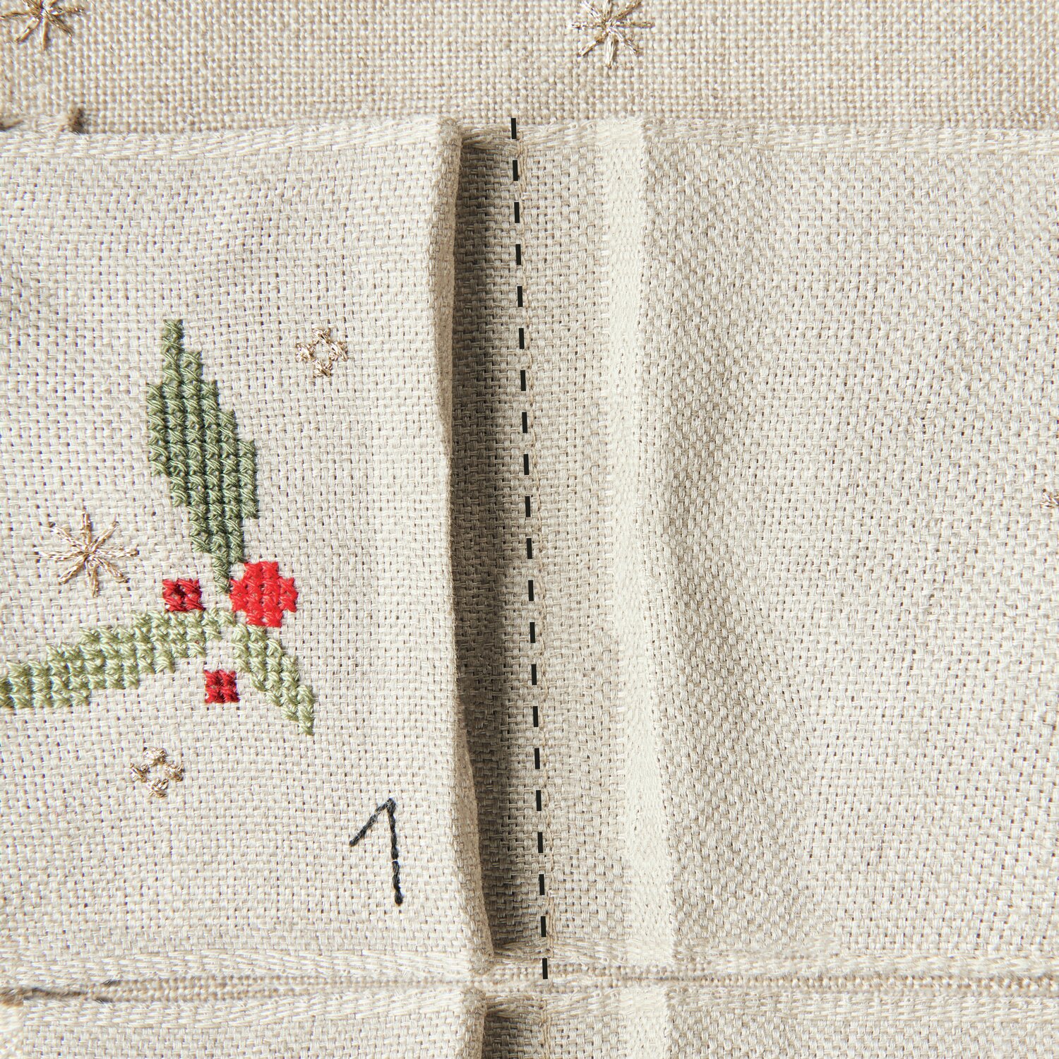 Stickpackung Adventskalender mit Taschen 30x76cm von Rico Design Stickbuch Put a Bow on It Nr. 185: Adventskalender mit Taschen, bestickt mit roten Beeren und grünen Blättern auf beigem Stoff.