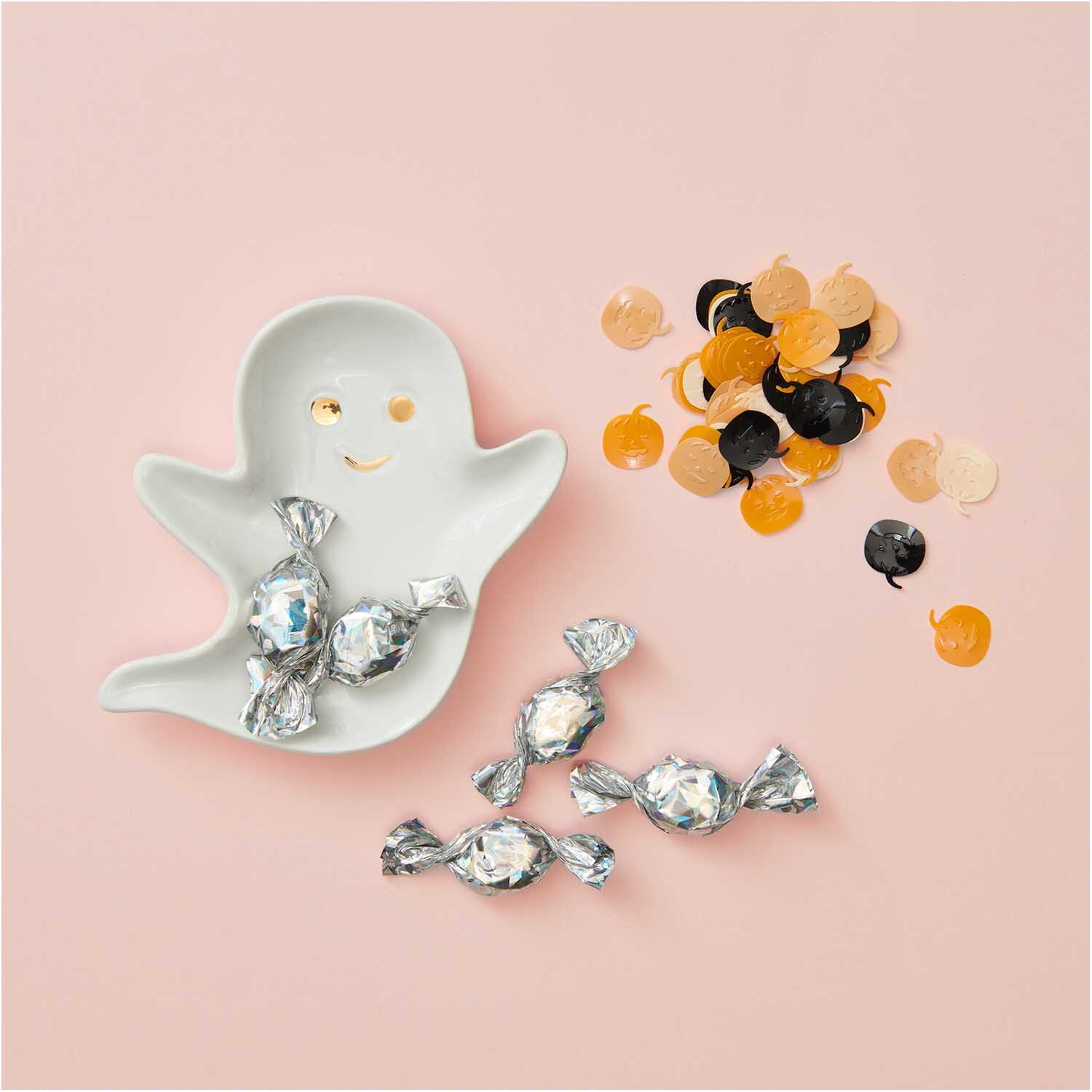 Flitterstreu Kürbis orange-schwarz 200 Stück von Rico Design Flitterstreu Kürbis orange-schwarz 200 Stück, dekorativ auf rosa Hintergrund mit Geisterschale.