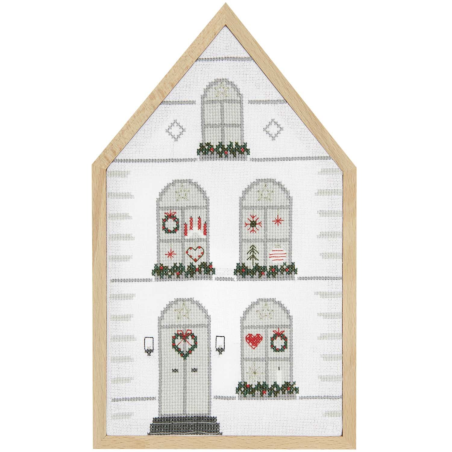 Stickpackung Haus groß 16x27cm von Rico Design zeigt ein gesticktes Haus mit weihnachtlichen Motiven und Holzrahmen.