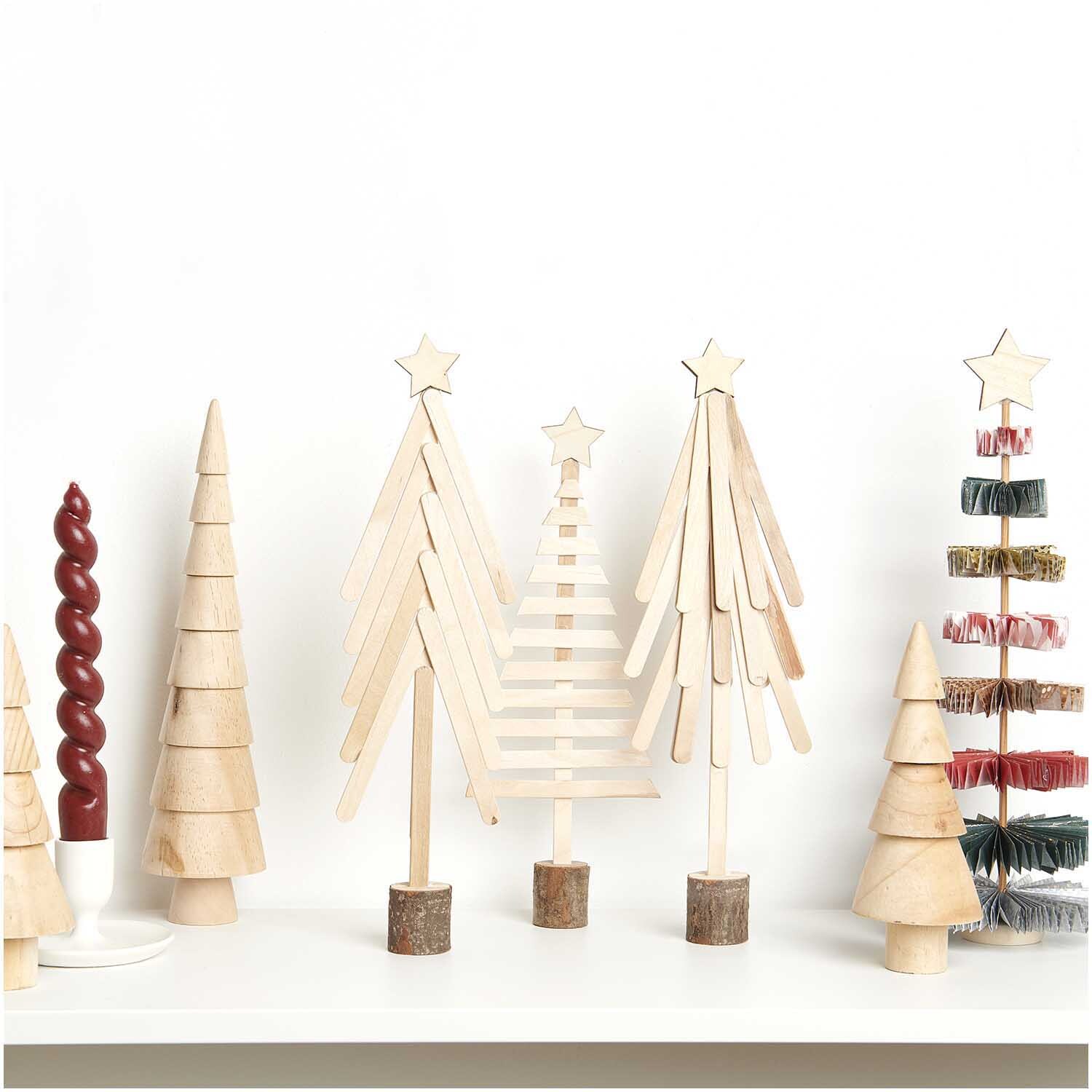 Bastelset Holz-Bastelstiele Tanne 66-teilig von Rico Design Bastelset Holz-Bastelstiele Tanne von Rico Design, 66-teilig. Verschiedene Holz-Tannenbäume auf einem Regal.
