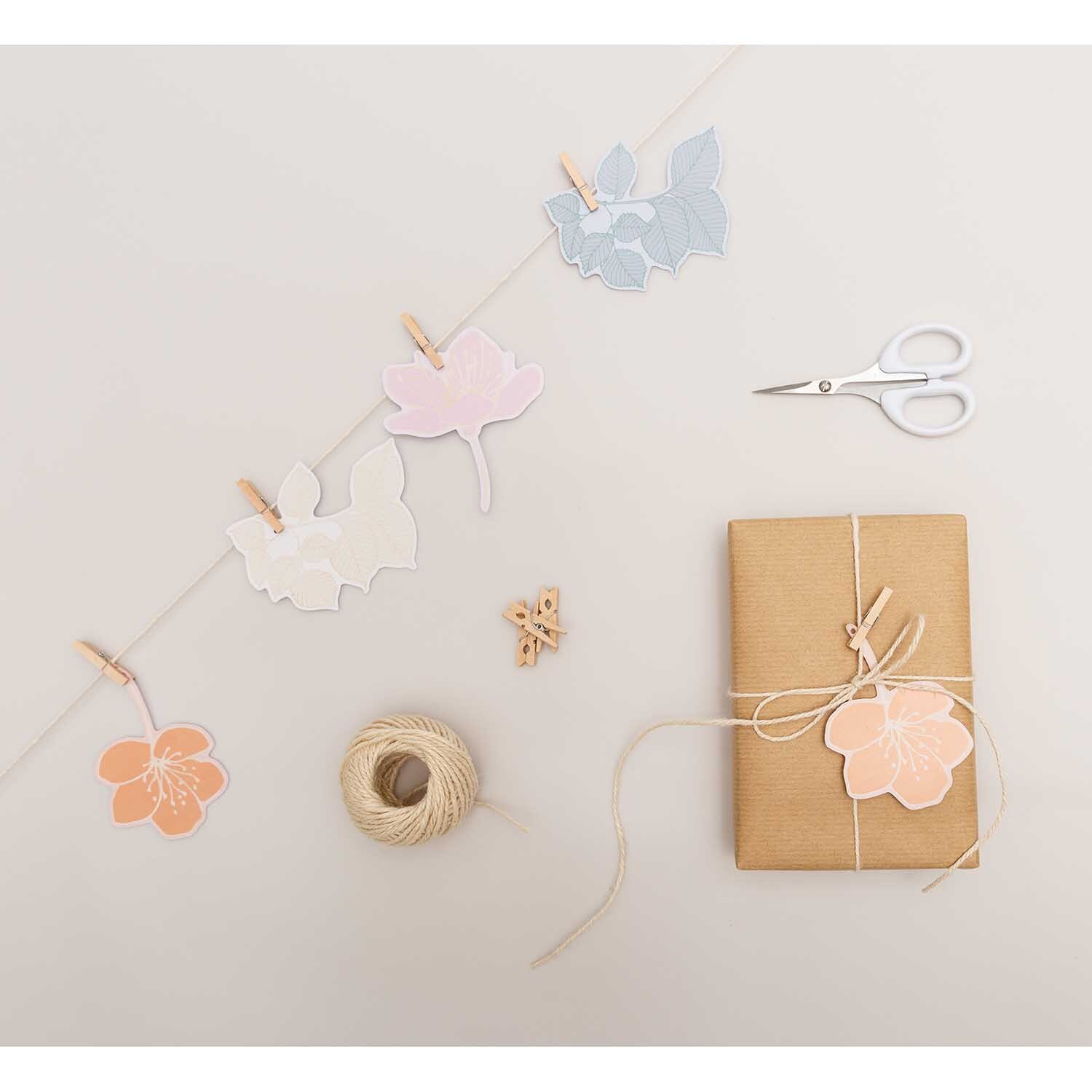Paper Poetry Papieranhänger Blüten 8 Stück von Rico Design Paper Poetry Papieranhänger Blüten 8 Stück, dekorativ arrangiert mit Schere, Garn und Geschenk.
