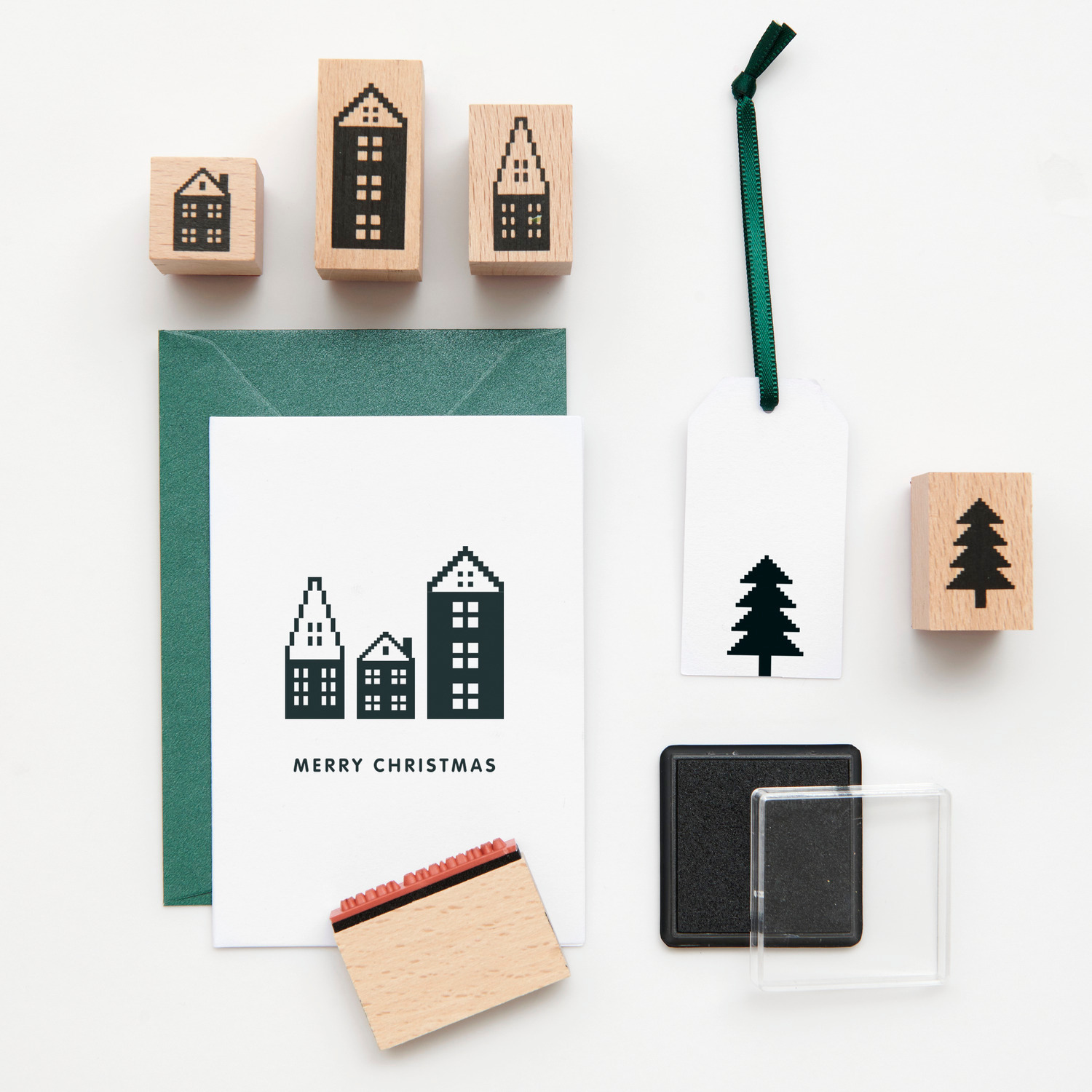 Paper Poetry Stempelset Häuser: Zehn Stempel mit Häuser- und Baumdesigns, ideal für kreative Weihnachtskarten.