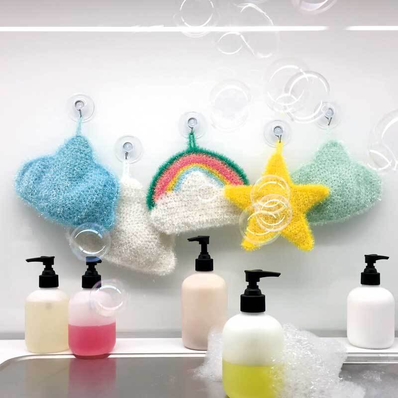 Creative Bubble: Bunte, gehäkelte Schwämme in Form von Wolken, Regenbogen und Sternen, dekorativ aufgehängt.