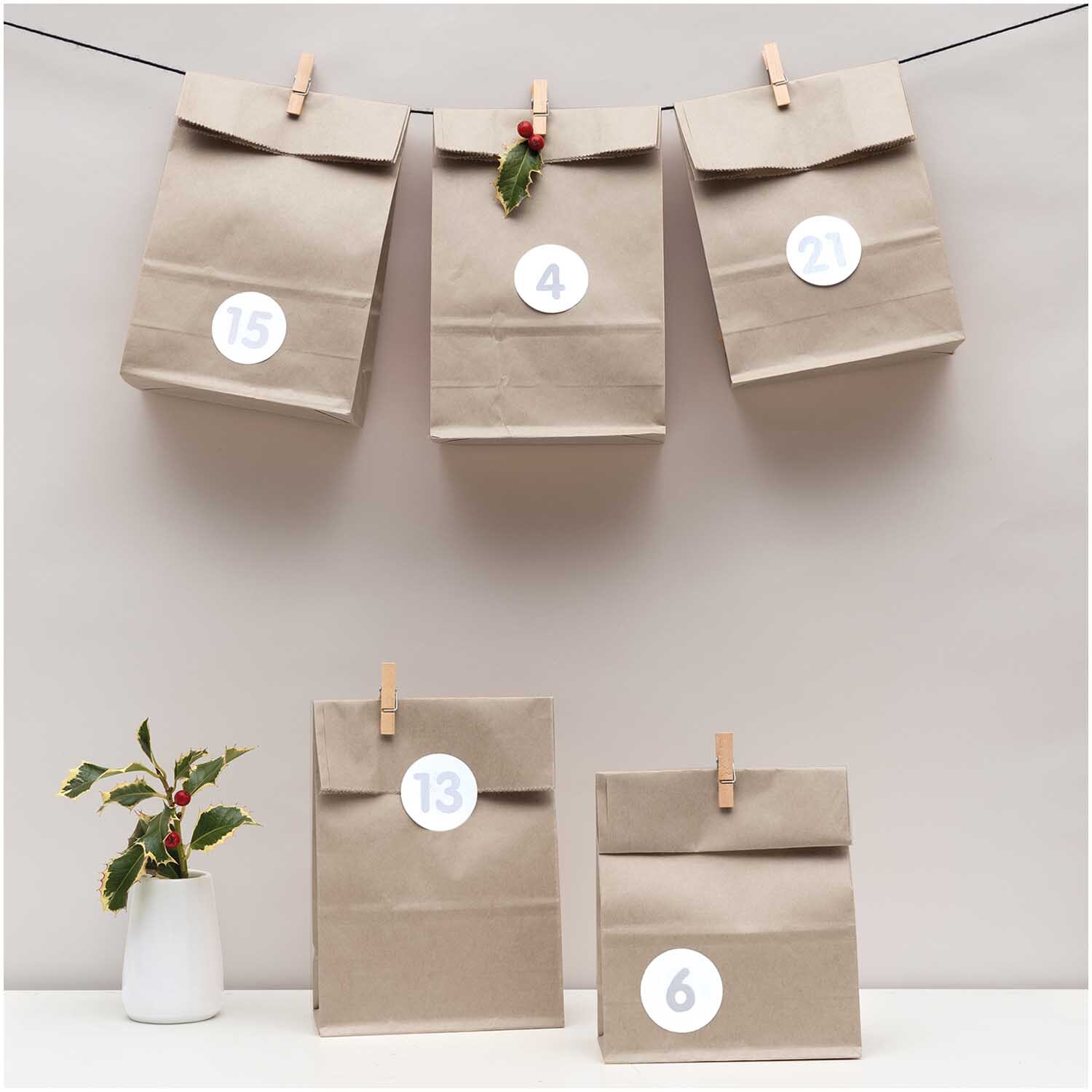 Paper Poetry Adventskalenderset grau mit 24 Tüten, dekoriert mit Zahlen und Clips, ideal für kreative Weihnachtsvorbereitungen.