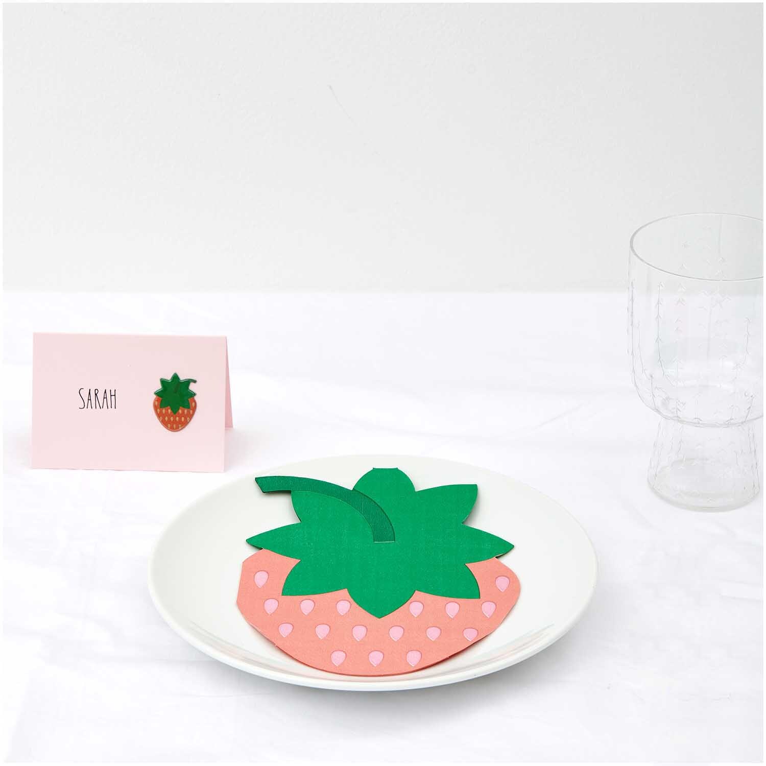 Servietten Erdbeere 12x16cm 20 Stück von Rico Design Servietten Erdbeere 12x16cm 20 Stück: Erdbeerförmige Servietten auf einem Teller, dekorativ arrangiert neben einem Namenskärtchen. Ideal für sommerliche Anlässe.