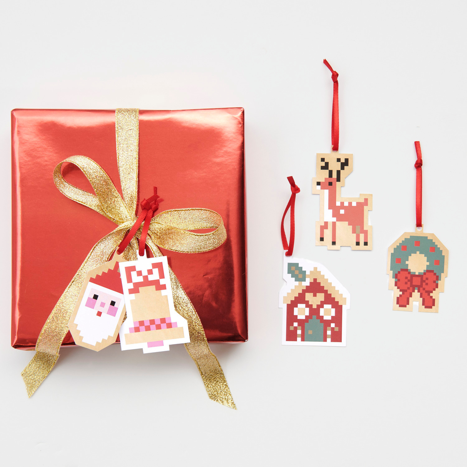 Paper Poetry Geschenkanhänger S Figuren Pixel 5x6,5cm 8 Stück von Rico Design Paper Poetry Geschenkanhänger S Figuren Pixel: Rotes Geschenk mit goldener Schleife und pixeligen Anhängern in Tier- und Weihnachtsmotiven.