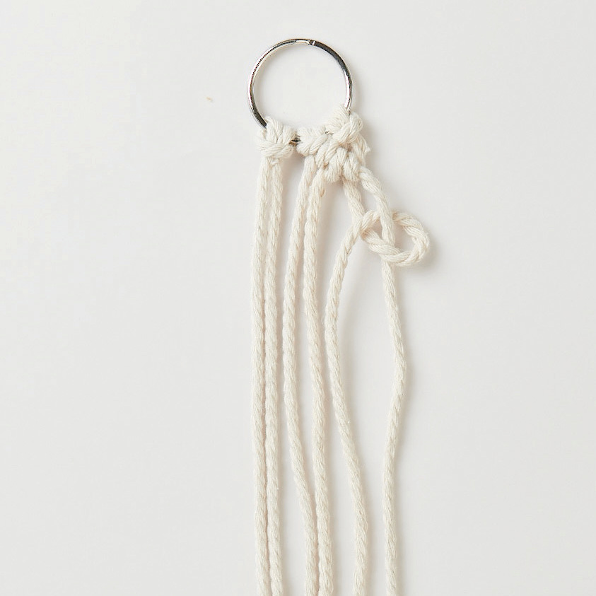 Set de macramé porte-clés 3 pièces from Rico Design Makramee Set Schlüsselanhänger von Rico Design mit drei weißen Schnüren an einem Metallring.