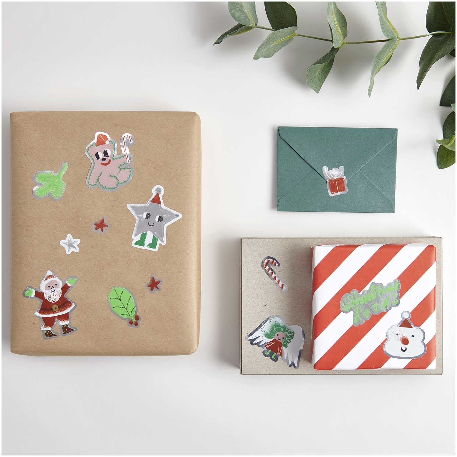 Paper Poetry Sticker Christmas Rocks! Airbrush Ø 5cm 100 Stück auf der Rolle von Rico Design Paper Poetry Sticker Christmas Rocks! auf Geschenken und Karten, dekoriert mit festlichen Motiven. Ideal für kreative Weihnachtsverpackungen.