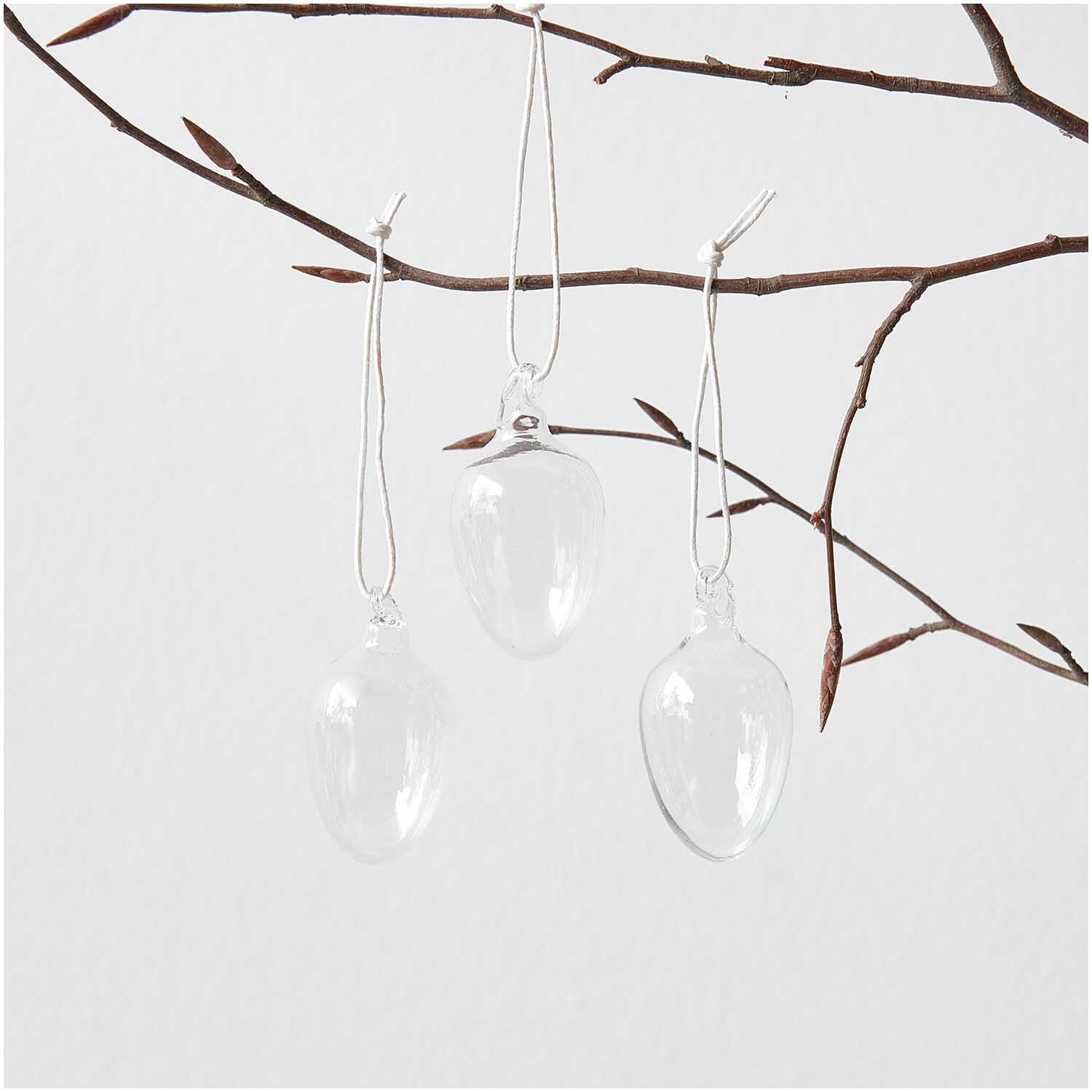 Glas Eier transparent 4 Stück Ø 3cm von Rico Design Glas Eier transparent 4 Stück Ø 3cm von Rico Design hängen an einem Ast, ideal für Dekoration.
