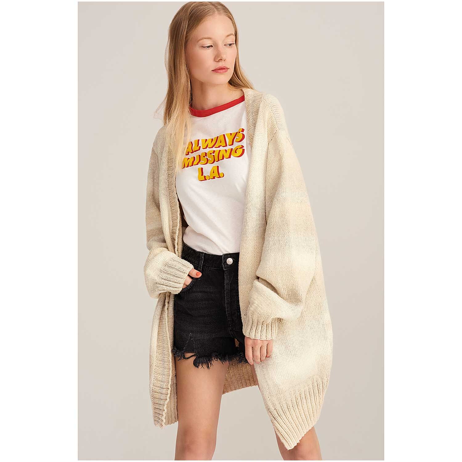Fashion Cotton Light & Long dk 50g 185m Couleur Nature from Rico Design Fashion Cotton Light & Long dk: Frau trägt langen, beigen Cardigan von Rico Design über T-Shirt und Shorts.