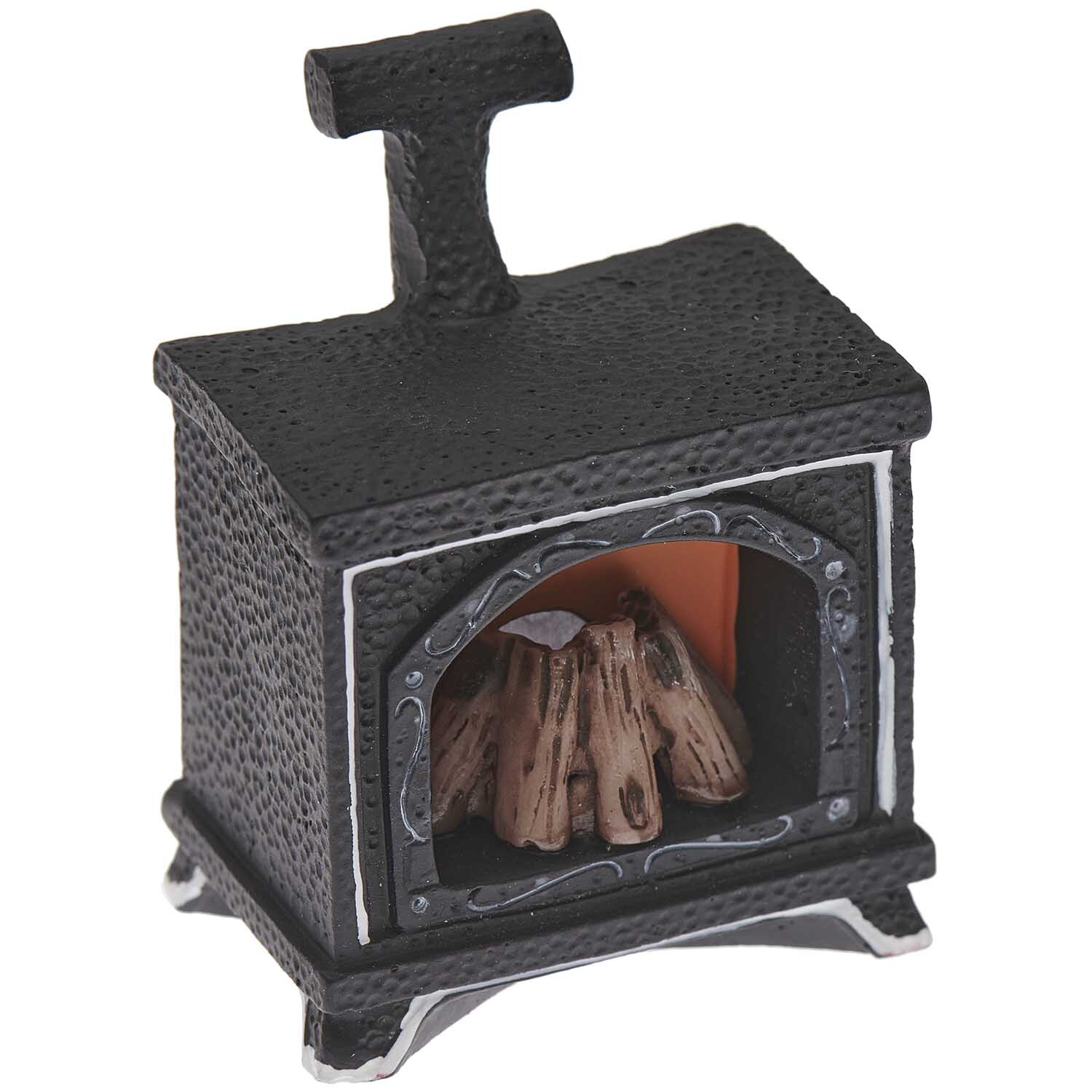 Miniatur Kamin mit Licht, dekorativer schwarzer Ofen von Rico Design, zeigt Holzscheite im Inneren. Maße: 7x4,8x2,2cm.