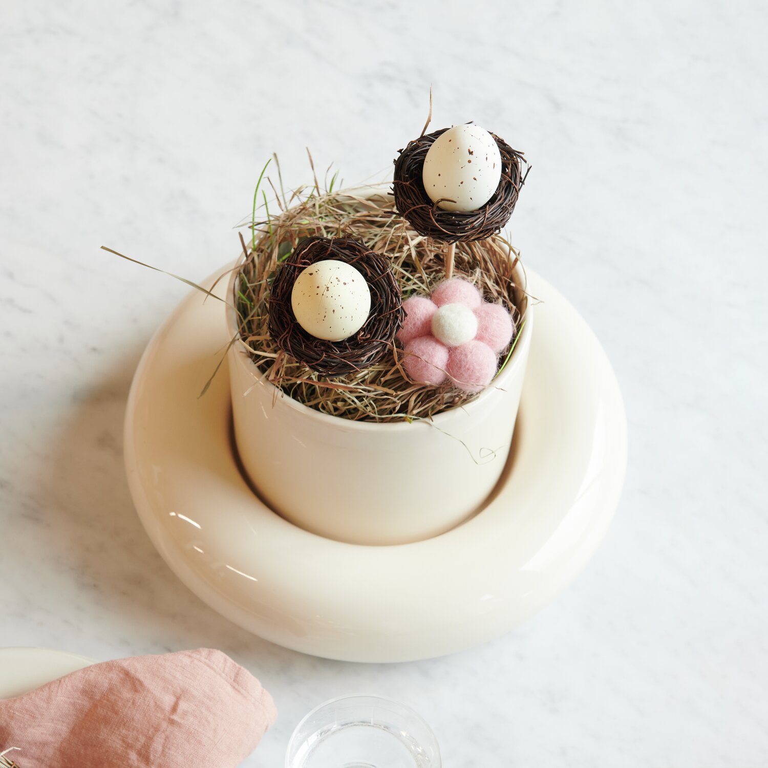 Aufhänger Filz-Blumen 5,7x3cm 3 Stück von Rico Design Stecker Ei im Nest: Dekoratives Arrangement mit Filz-Blumen in Naturtönen auf weißem Untergrund.