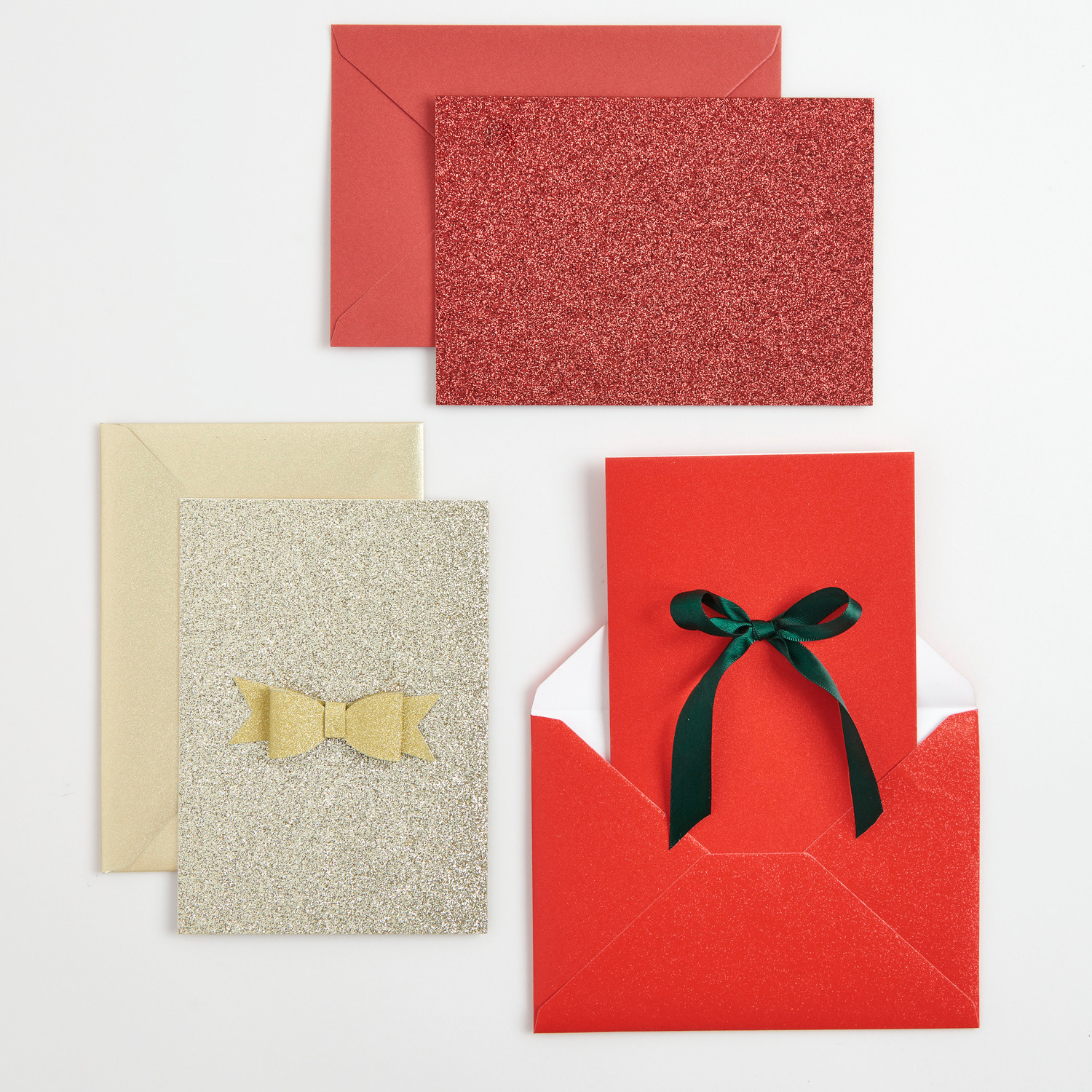 Paper Poetry Karten- und Umschlagset Glitter B6 Rot 16-teilig von Rico Design Paper Poetry Karten- und Umschlagset Glitter B6 Gold: Elegantes Set mit goldenen und roten Karten, verziert mit Schleifen, ideal für festliche Anlässe.