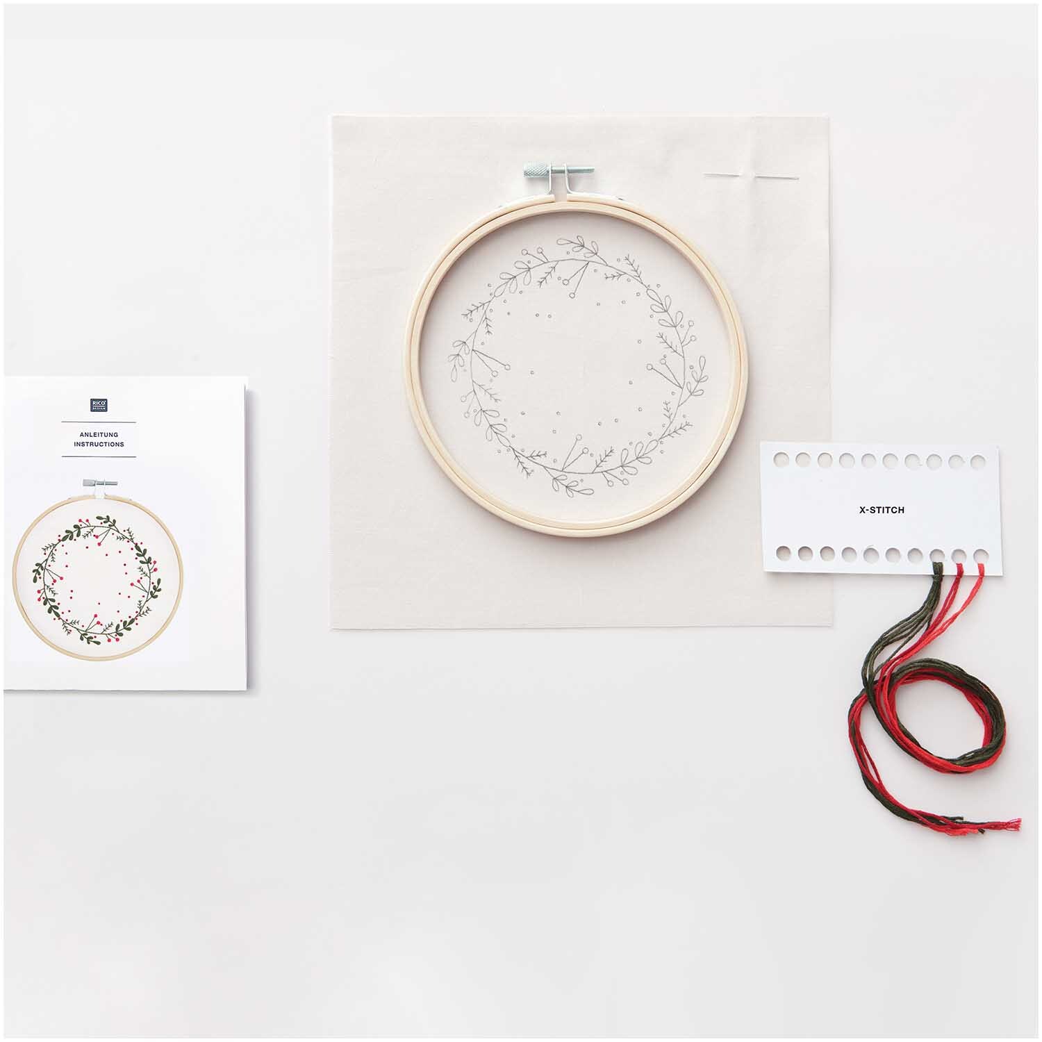 Paquet à broder Couronne Image Ø 15cm from Rico Design Stickpackung Kranz Bild Ø 15cm von Rico Design zeigt einen Stickrahmen mit floralem Muster, Garn und Anleitung.
