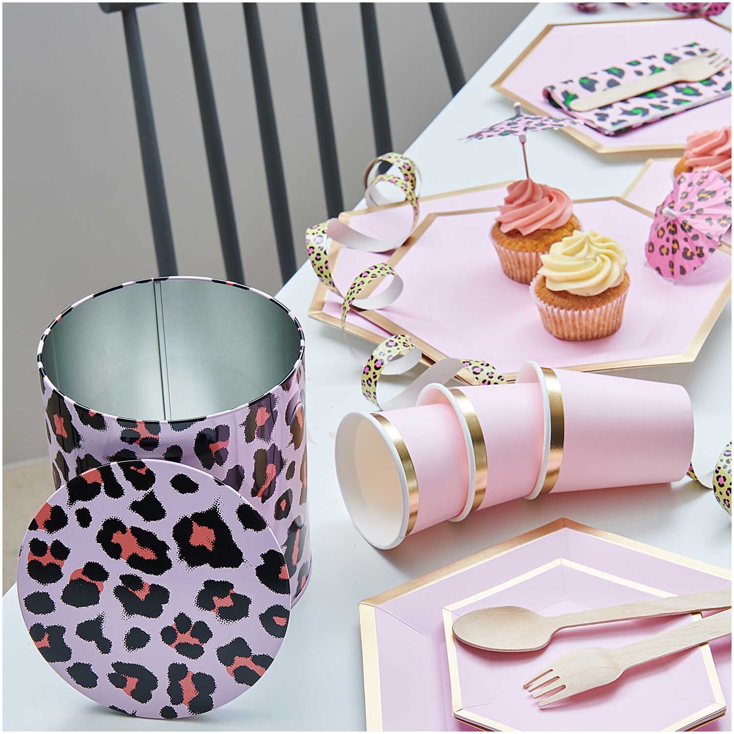 Keksdose Acid Leo 13,6x15,1cm Farbe Rosa von Rico Design Keksdose Acid Leo 13,6x15,1cm mit Leopardenmuster, umgeben von rosa Partygeschirr und Cupcakes.