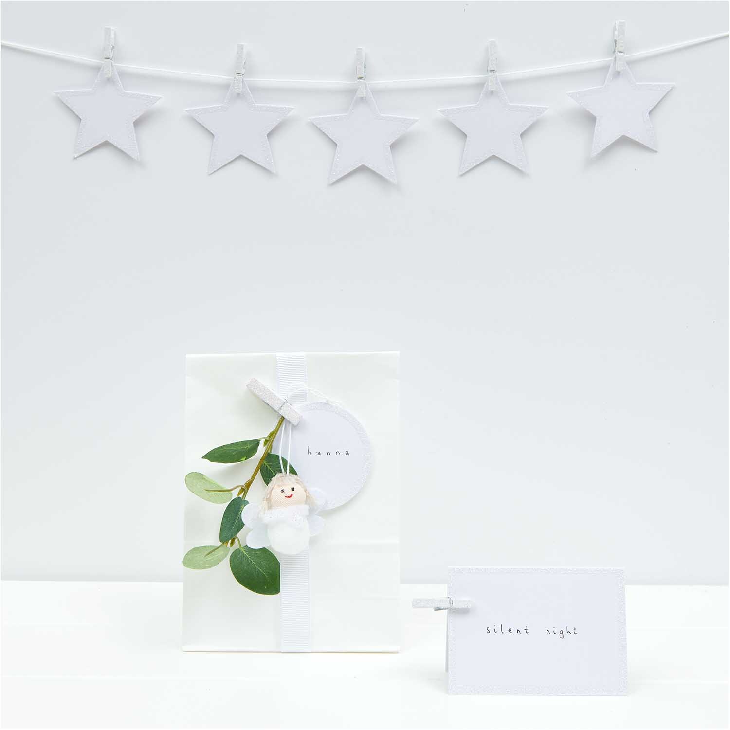 Paper Poetry Papieranhänger in Kreisform mit Glitter, dekoriert mit Sternen und Geschenkverpackung. Ideal für festliche Anlässe.