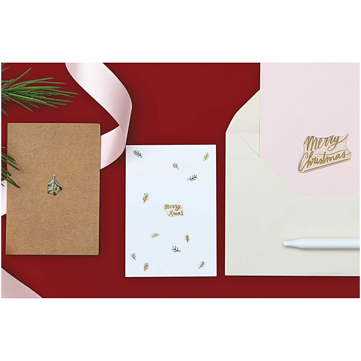 Paper Poetry Gelsticker Jolly Christmas pastell: Weihnachtskarten-Set mit pastellfarbenen Stickern und Umschlägen auf rotem Hintergrund.