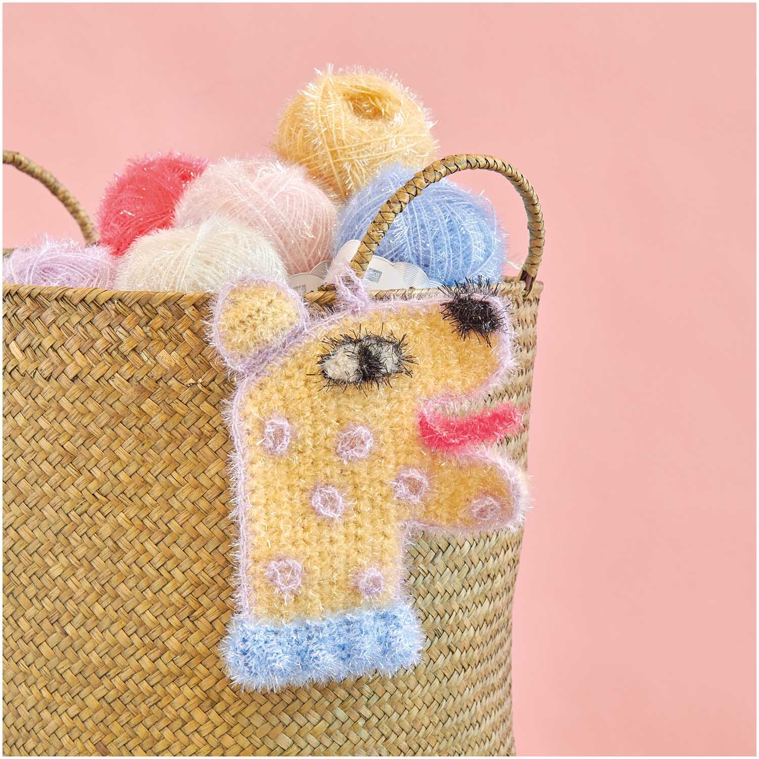 Creative Bubble: Bunte Garnknäuel in einem Korb mit gehäkeltem Tiermotiv, ideal für kreative Projekte.