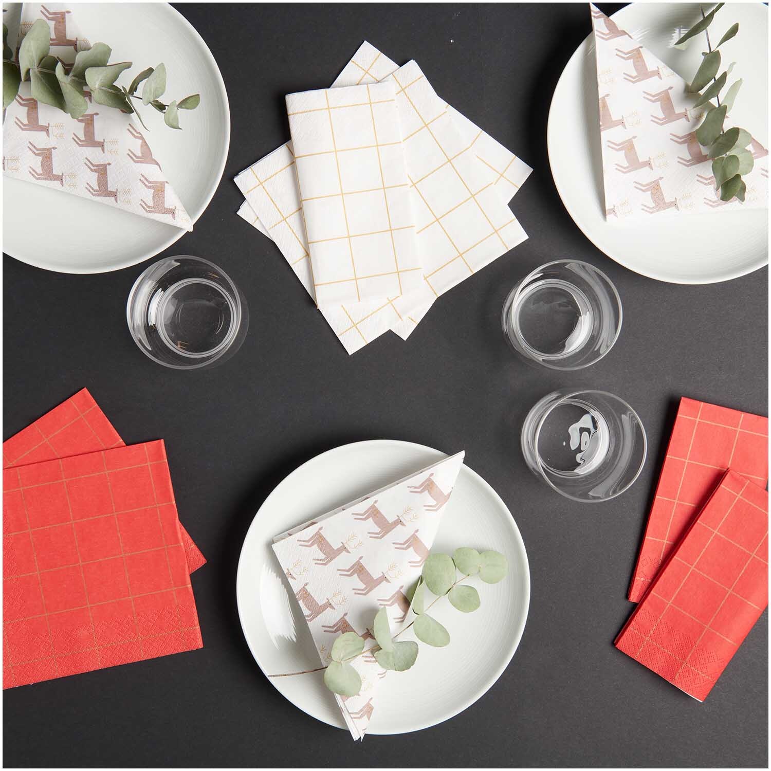 Servietten Rentiere 33x33cm 20 Stück von Rico Design Servietten Rentiere 33x33cm 20 Stück, dekorativ auf Tellern arrangiert, mit Eukalyptuszweigen und Gläsern, von Rico Design.