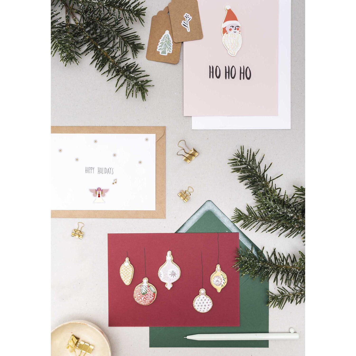 Paper Poetry Gelsticker Engel 1 Blatt von Rico Design Paper Poetry Gelsticker Engel 1 Blatt: Mehrfarbige Weihnachtskarten mit festlichen Motiven und Dekorationen auf einem Tisch arrangiert.