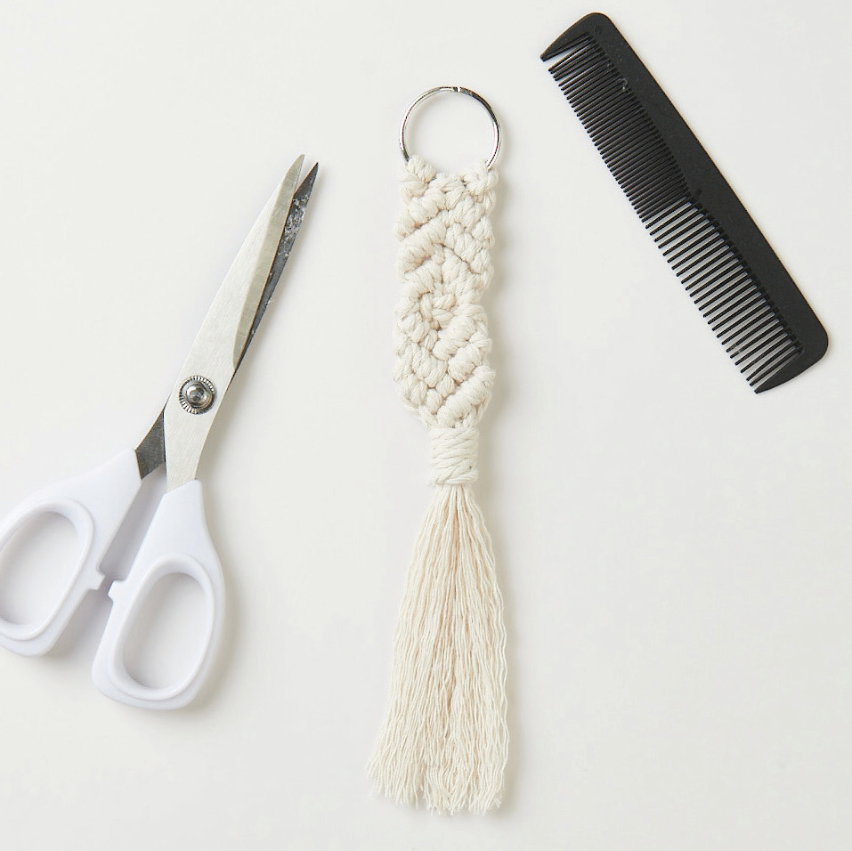 Set de macramé porte-clés 3 pièces from Rico Design Makramee Set Schlüsselanhänger mit weißem Knoten-Design, begleitet von einer Schere und einem Kamm. Ideal für kreative Projekte.