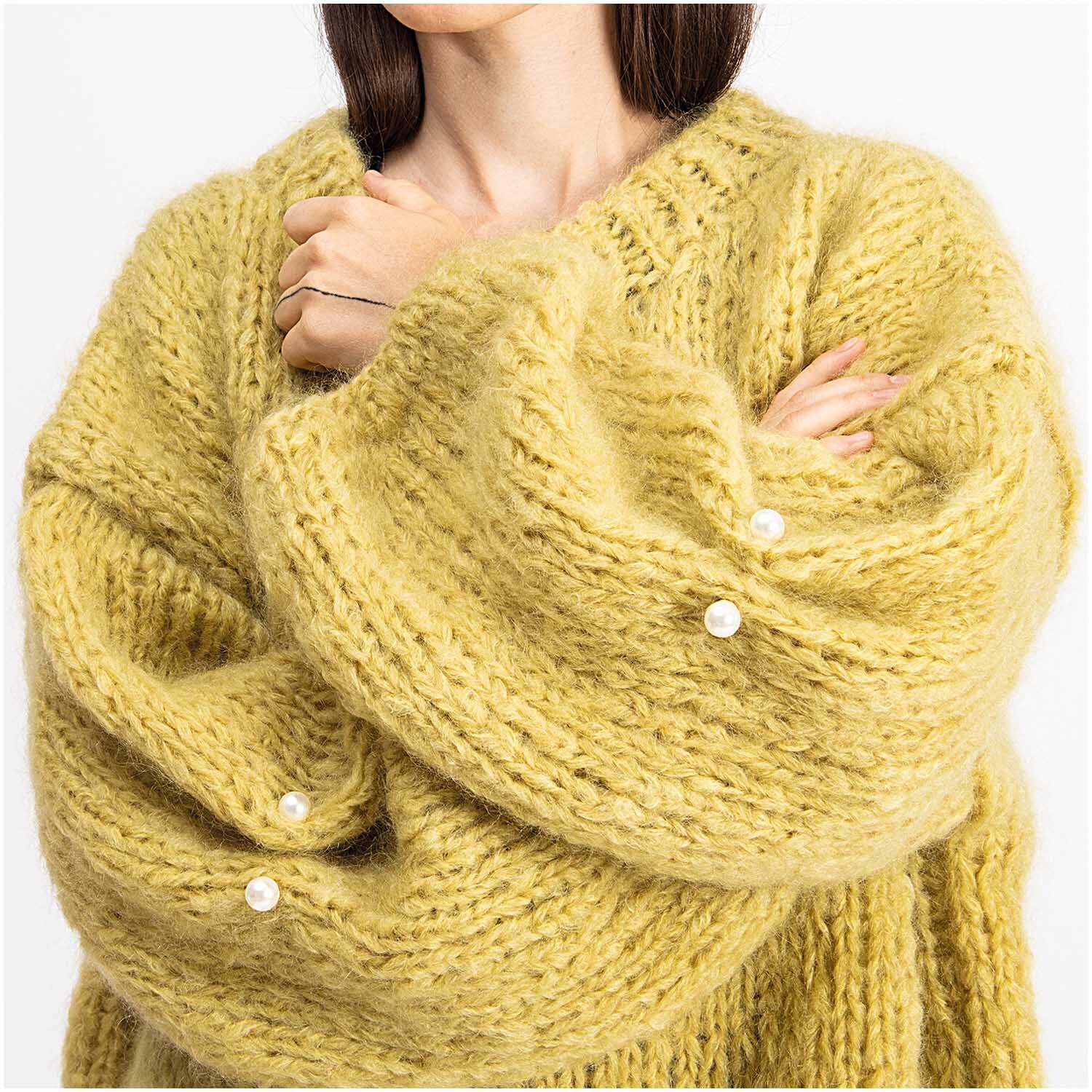 Zwei-Perlen-Pin 48mm 1 Stück Farbe Perlweiß von Rico Design Zwei-Perlen-Pin 48mm 1 Stück: Frau trägt gelben Strickpullover mit perlweißen Pins von Rico Design.
