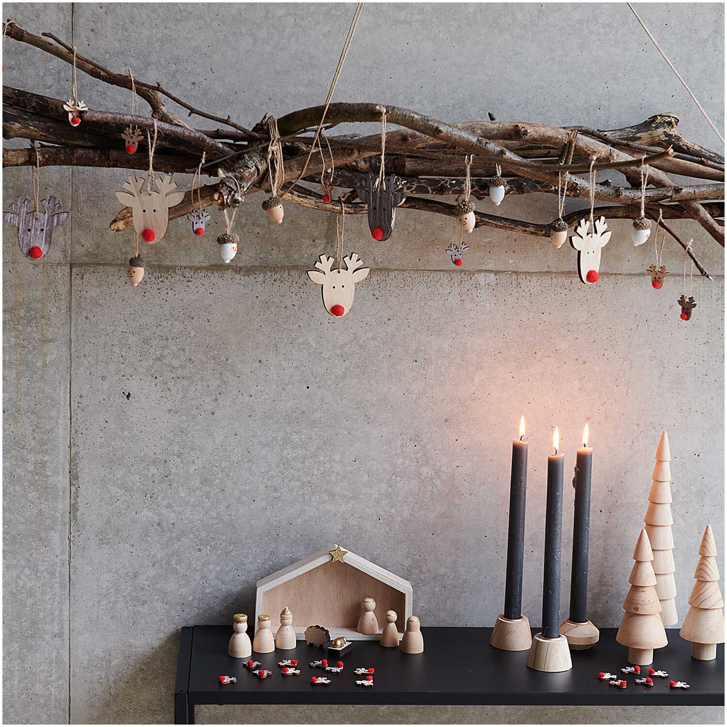 Holzhänger Schneemann weiß-braun 20x25mm 6 Stück von Rico Design Holzhänger Schneemann in Weiß-Braun von Rico Design, dekoriert an einem Ast mit Kerzen und Holzfiguren.