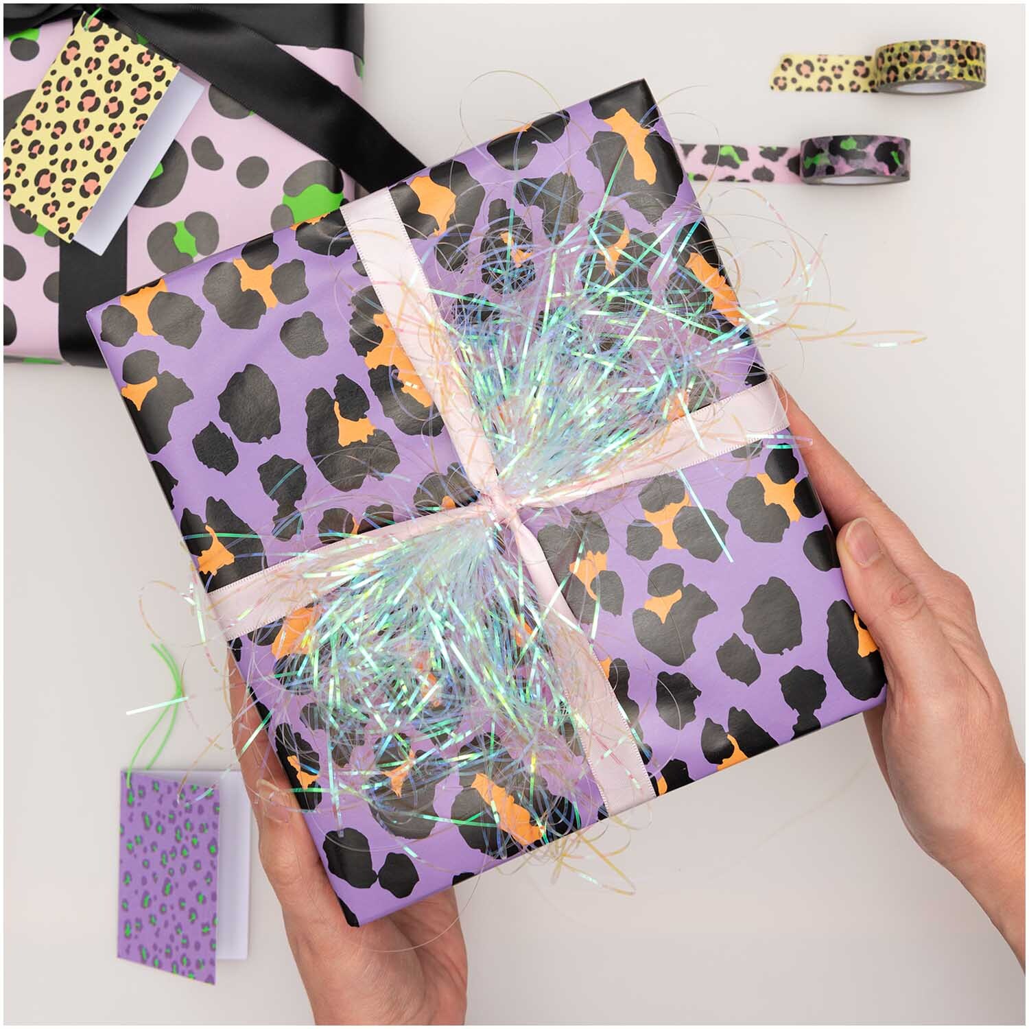 Paper Poetry Geschenkpapier Acid Leo flieder 70cm 3m 70g/m² von Rico Design Paper Poetry Geschenkpapier mit Leopardenmuster in Flieder, verpackt als Geschenk mit buntem Band.