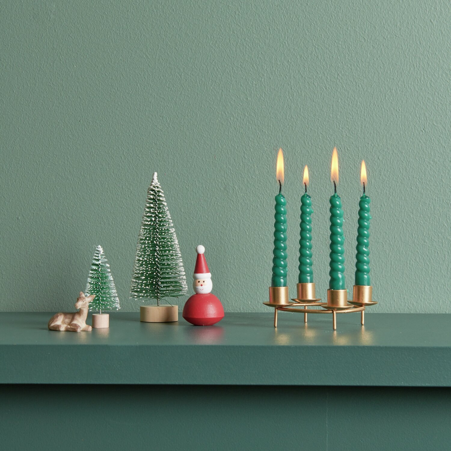 Spiralkerzen grün Mix 1,2x10cm 10 Stück, dekoriert mit Mini-Adventskerzenhalter „Wald“ von Rico Design, auf einem grünen Regal.