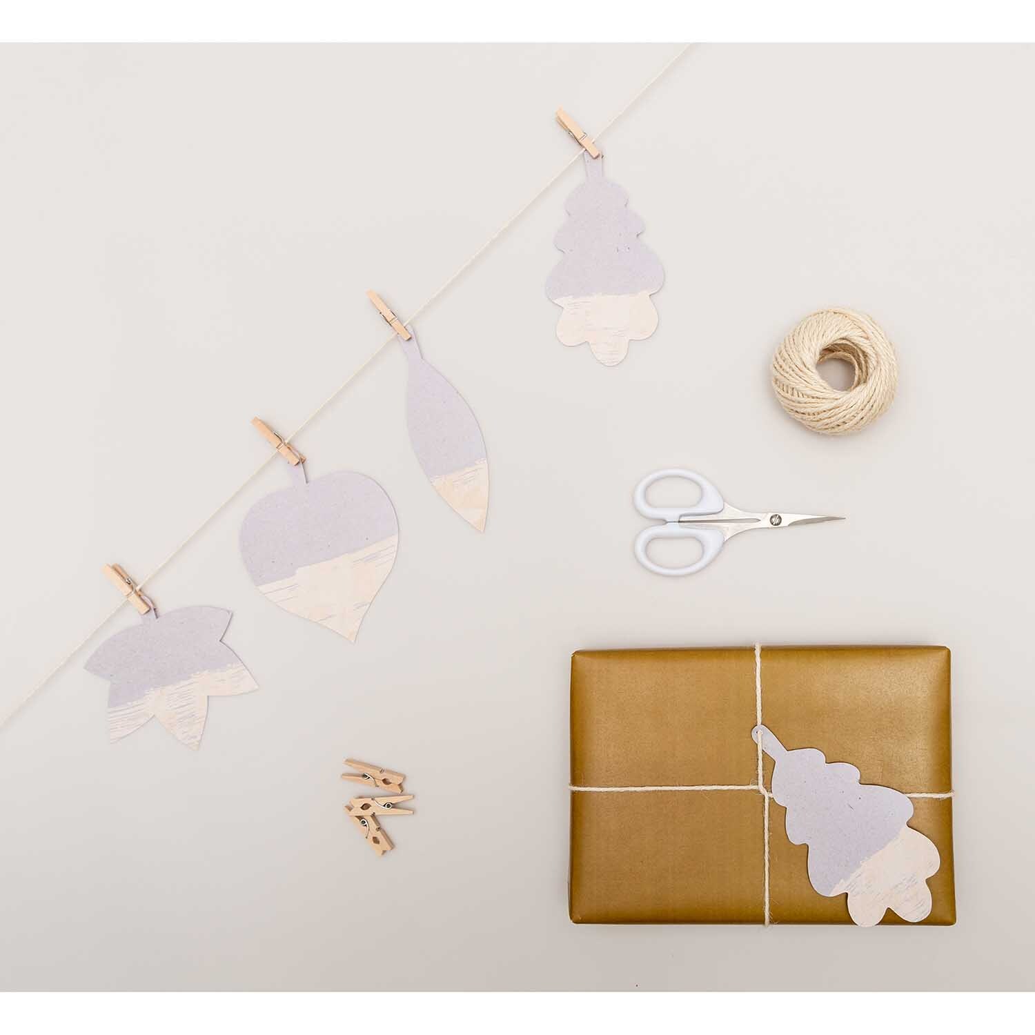 Paper Poetry Papieranhänger Blätter Graukarton 8 Stück von Rico Design Paper Poetry Papieranhänger Blätter Graukarton, dekorativ arrangiert mit Schere, Geschenk und Kordel auf hellem Hintergrund.