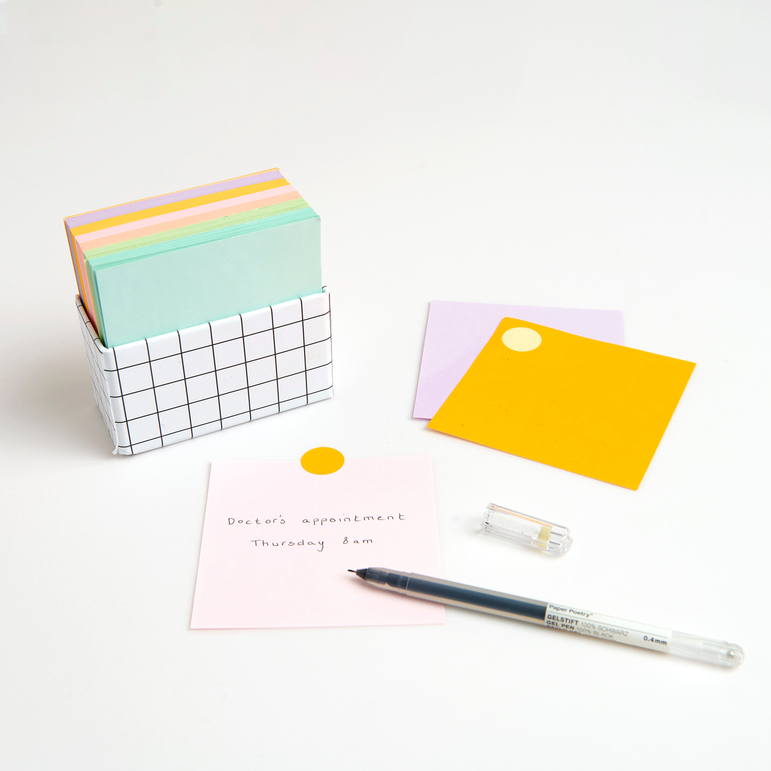 Paper Poetry Notizzettel-Box grün, orange, lila 9x9cm 400 Blatt von Rico Design Paper Poetry Notizzettel-Box mit 400 Blättern in grün, orange und lila, 9x9cm, auf weißem Tisch.