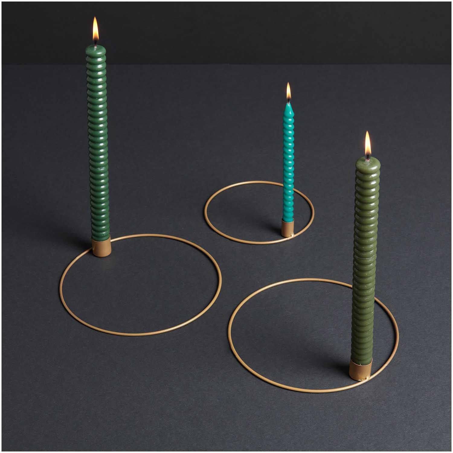 Metallring mit Kerzenhalter Ø 15cm Farbe Gold Matt von Rico Design Metallring mit Kerzenhalter Ø 15cm in Gold Matt von Rico Design, präsentiert mit drei brennenden Kerzen auf dunklem Hintergrund.