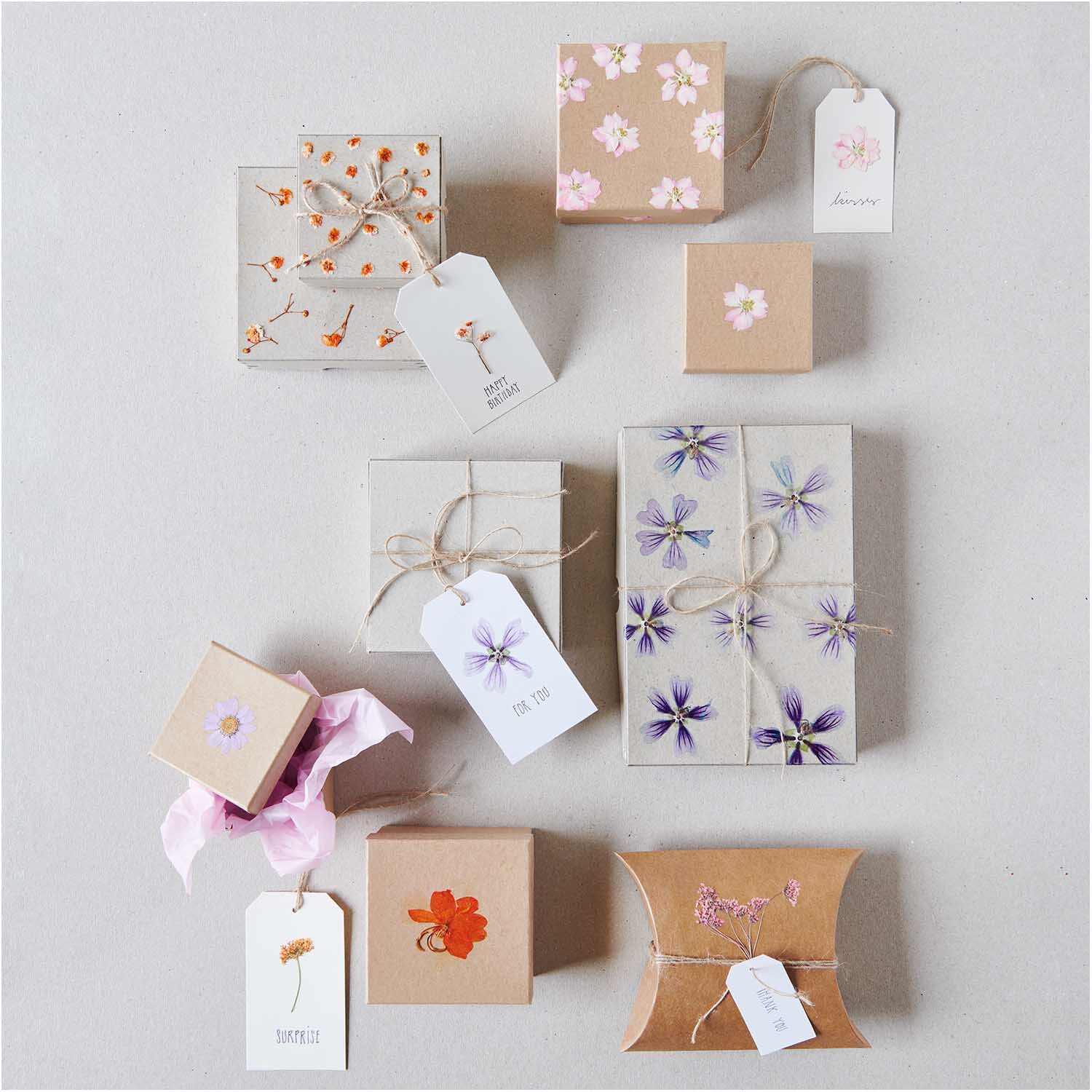 Paper Poetry Geschenkschachtel XXL aus Kraftpapier, dekoriert mit floralen Mustern und Geschenkanhängern, ideal für stilvolle Verpackungen.