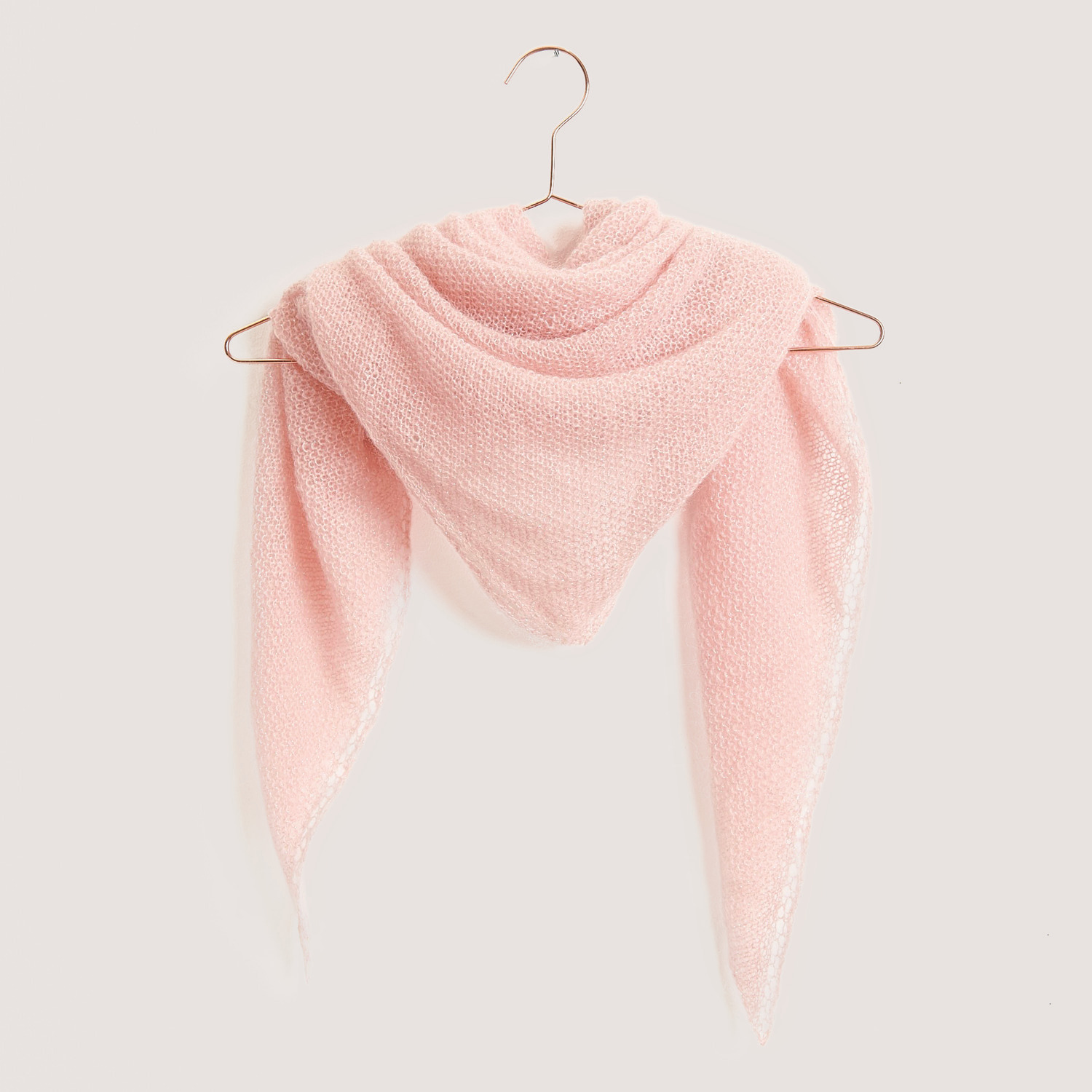 Essentials Super Kid Mohair Loves Silk Glamorous Glitter 25g 190m Couleur Abricot from Rico Design Essentials Super Kid Mohair Loves Silk Glamorous Glitter: Dreieckstuch in zartem Apricot, elegant drapiert auf einem Kleiderbügel.