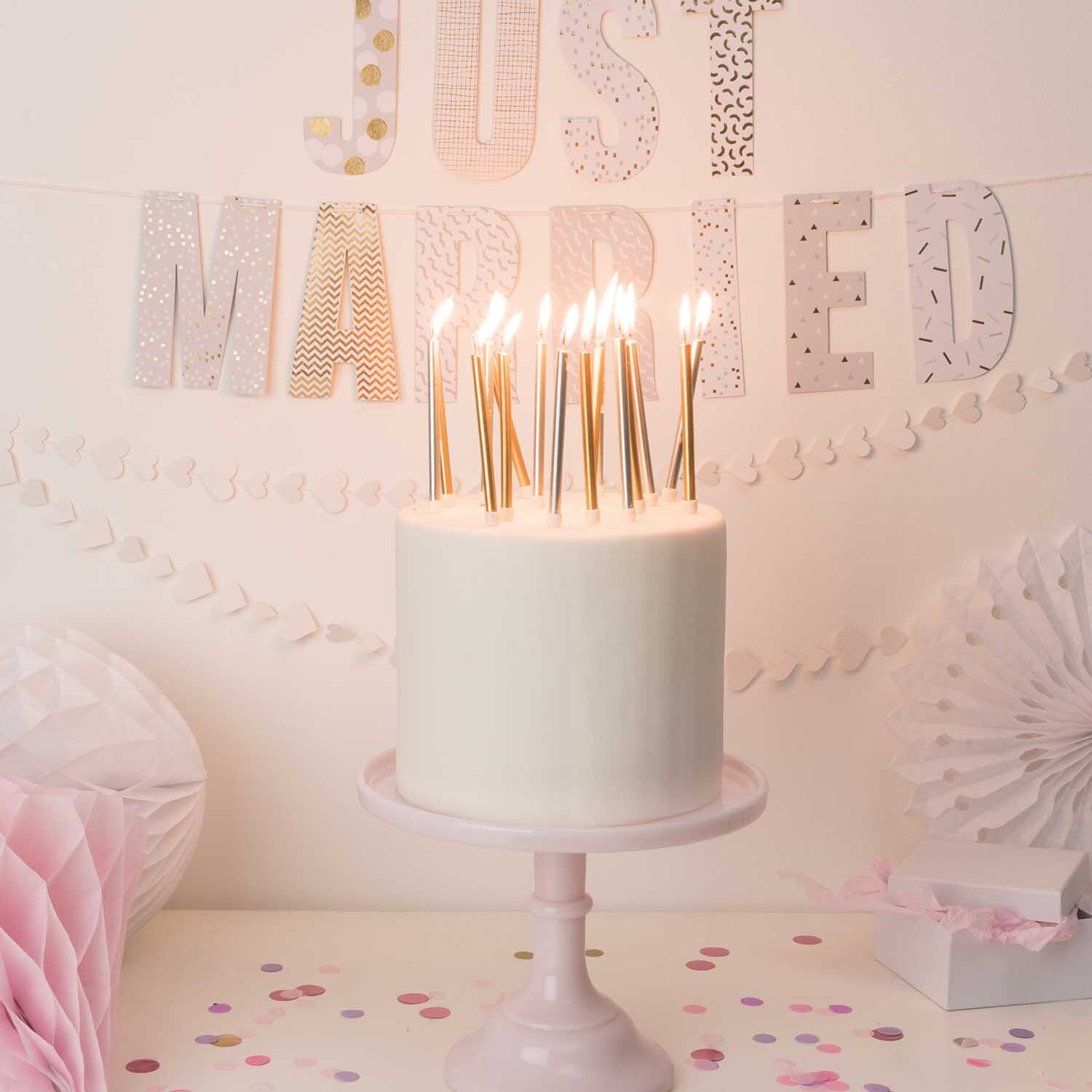 Kerzen lang 16 Stück auf einer Hochzeitstorte, umgeben von Dekorationen. Farben: Gold/Silber. Marke: Rico Design.