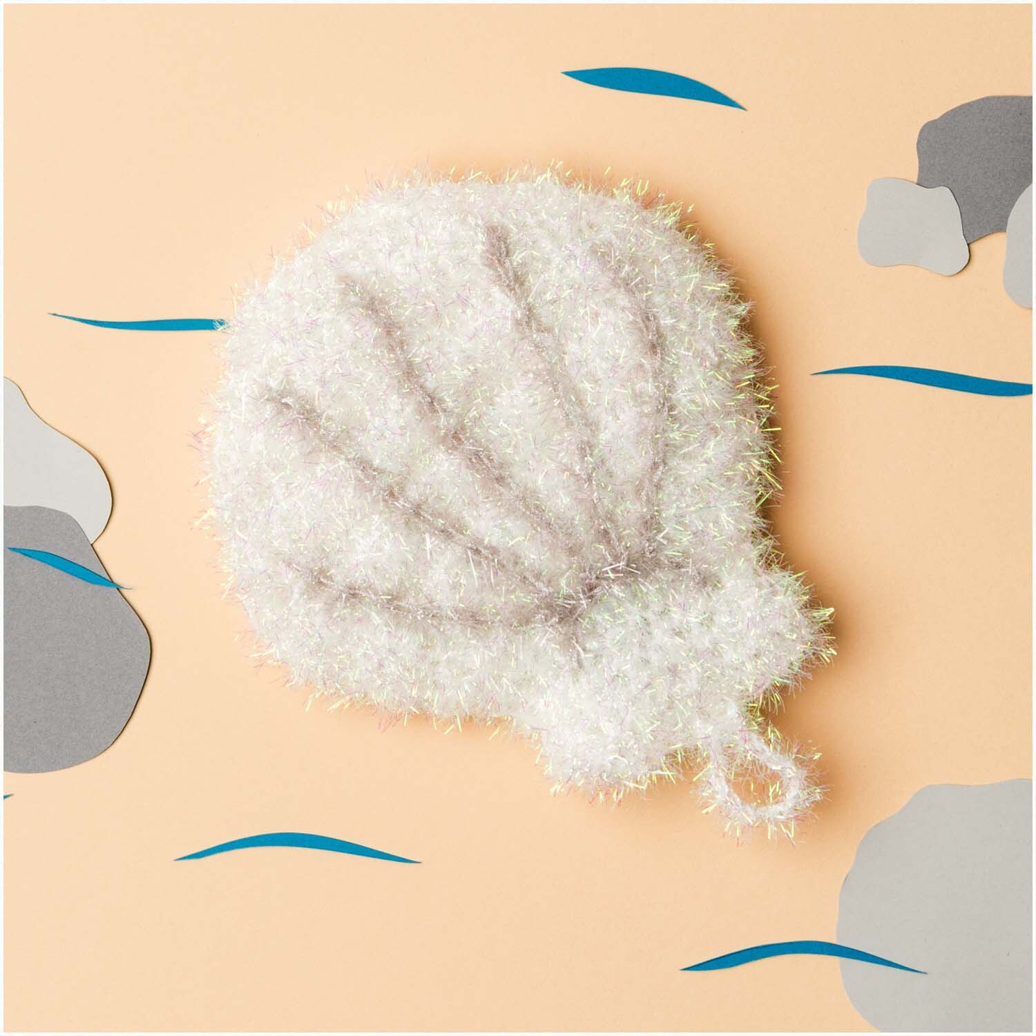 Creative Bubble - Beyond the Sea: Weiße, muschelförmige Struktur von Rico Design auf sandfarbenem Hintergrund.