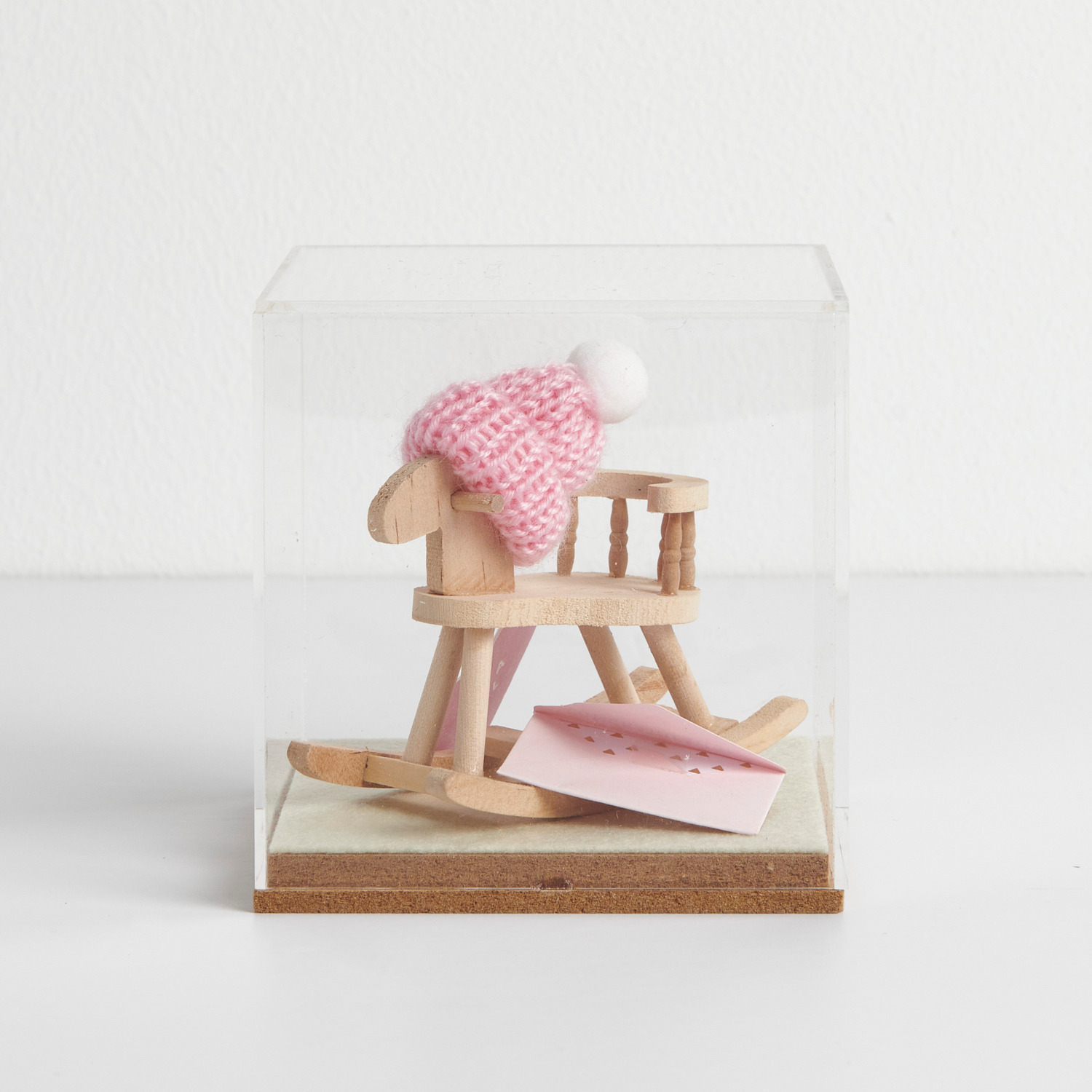 Figurico Dekohaube Würfel Größe 6x6x6,5cm von Rico Design Figurico Dekohaube Würfel mit einem Mini-Holzschaukelstuhl und rosa Strickmütze von Rico Design.