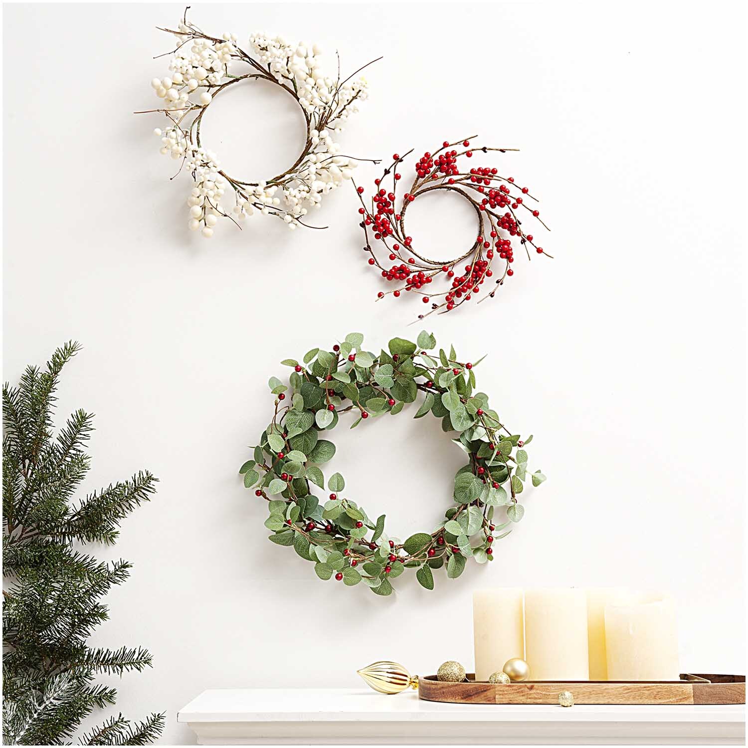 Beerenkranz rot Ø12cm von Rico Design: Ein dekorativer Kranz mit roten Beeren an der Wand.
