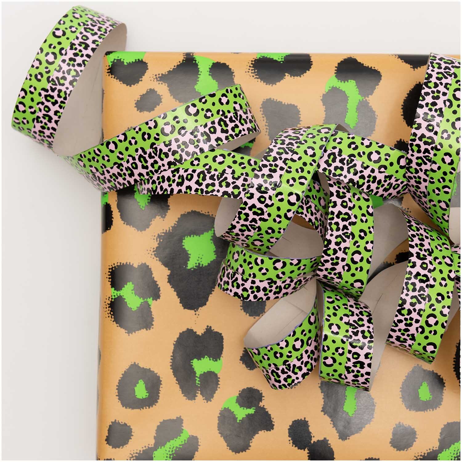 Banderoles Acid Leo argent 3,8m from Rico Design Luftschlangen Acid Leo silber 3,8m von Rico Design auf Geschenkpapier mit Leopardenmuster.