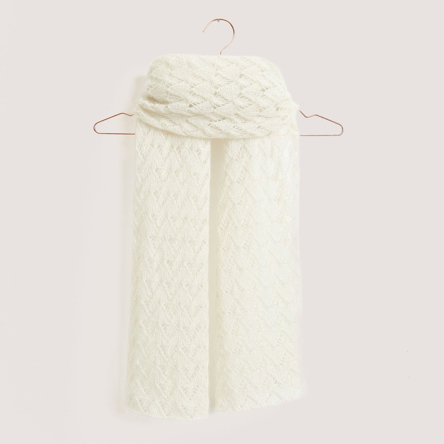 Essentials Super Kid Mohair Loves Silk Glamorous Glitter 25g 190m Couleur Crème from Rico Design Essentials Super Kid Mohair Loves Silk Glamorous Glitter Schal in Creme, elegant drapiert auf einem Kleiderbügel, zeigt feines Strickmuster.