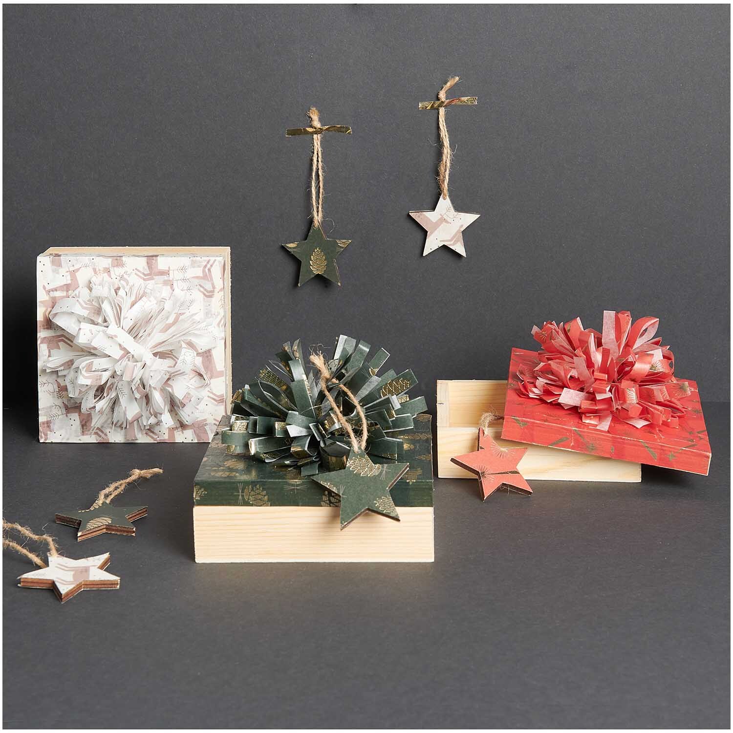 Paper Poetry Paper Patch Papier Tannenzapfen zeigt dekorative Geschenke mit Sternanhängern.