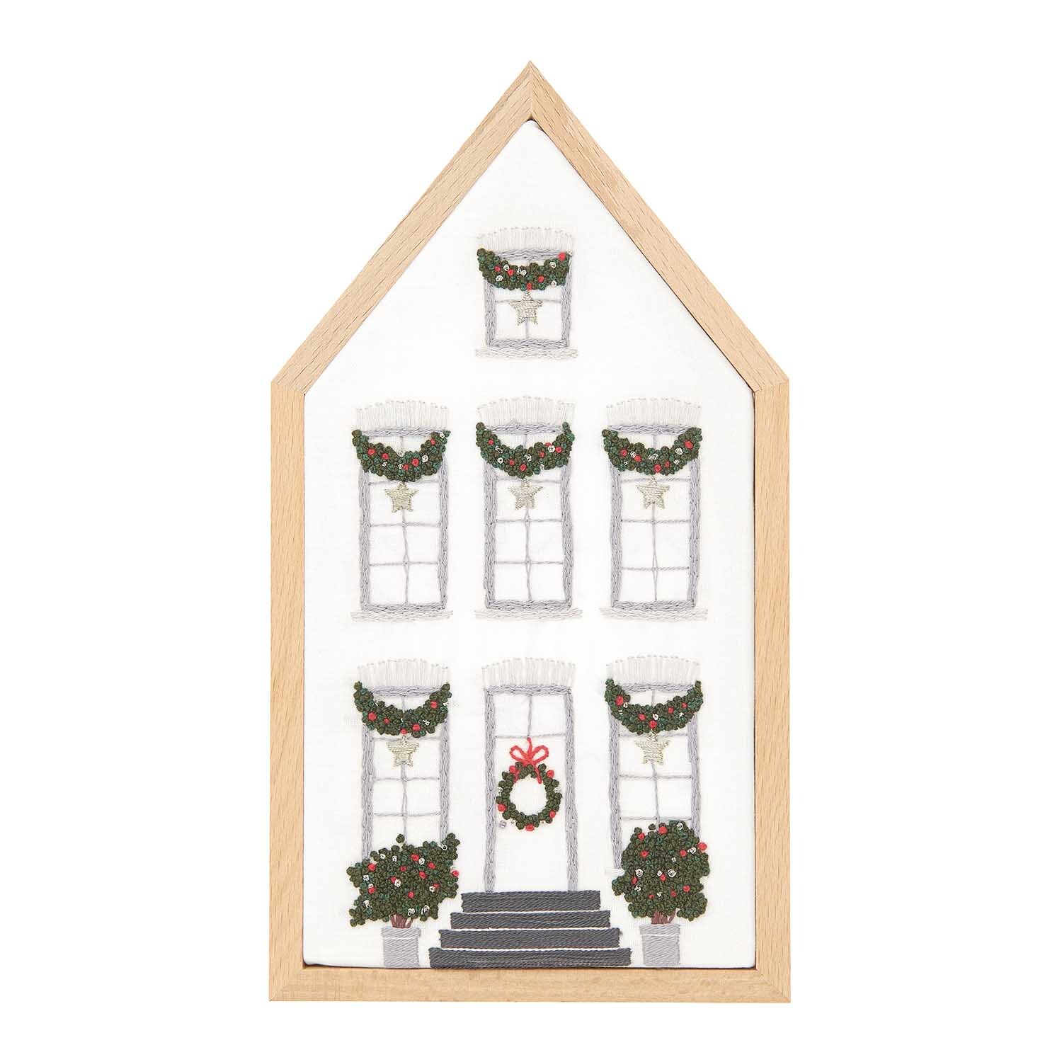 Stickpackung Haus mittel vorgezeichnet 12,5x22,5cm zeigt ein festlich dekoriertes Haus mit Kränzen an Fenstern und Tür, von Rico Design.