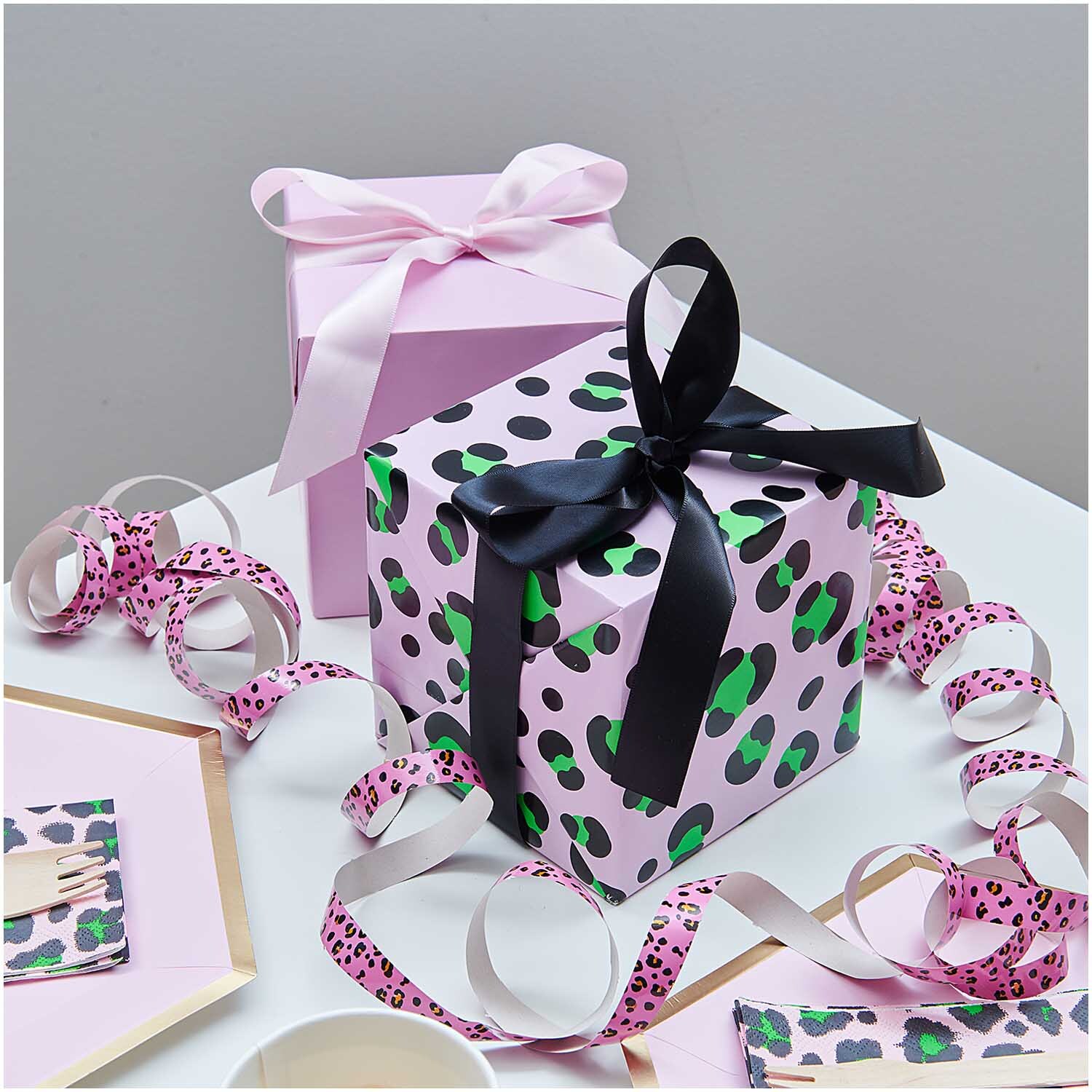 Paper Poetry Geschenkpapier Acid Leo rosa 70cm 3m 70g/m² von Rico Design Paper Poetry Geschenkpapier Acid Leo rosa zeigt ein Geschenk mit schwarzer Schleife und rosa Hintergrund. Ideal für stilvolle Verpackungen.