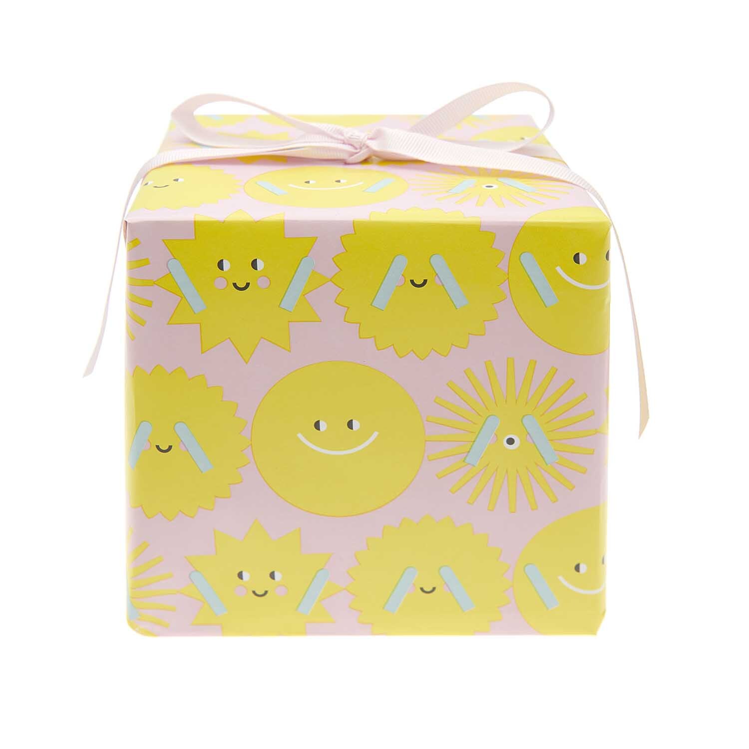 Paper Poetry Geschenkpapier zeigt fröhliche Sonnenmotive auf rosa Hintergrund, ideal für Geschenke.