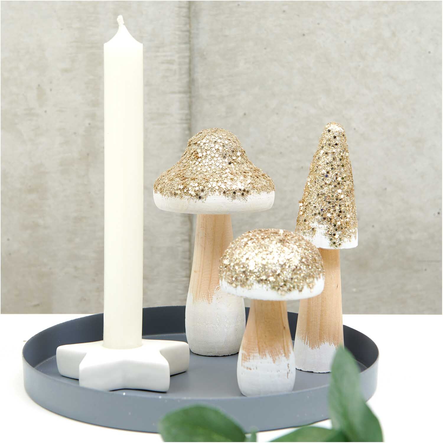 Holzpilz mit Glitter gold: Drei dekorative Holzpilze mit goldenen Glitzerdetails auf einem Tablett.