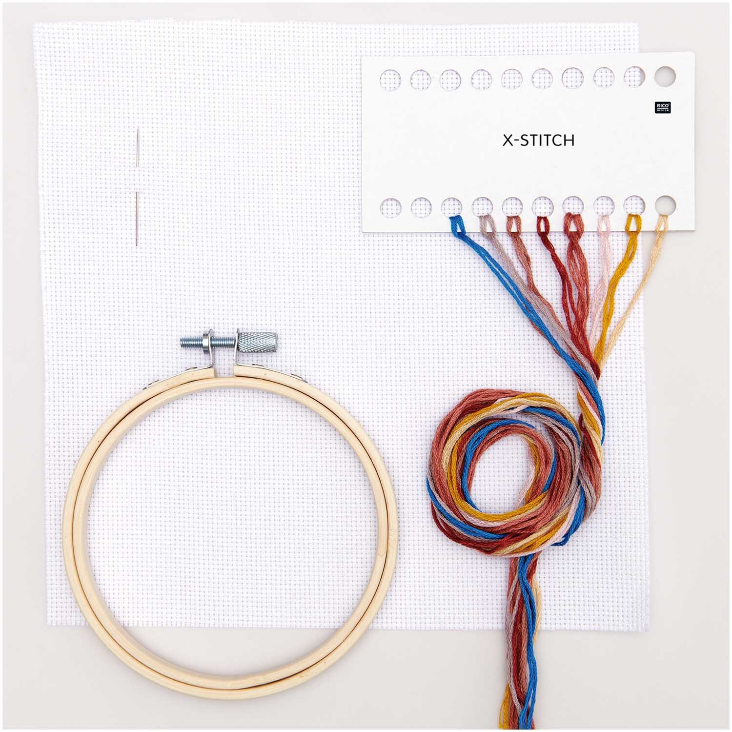 Kit de broderie Mini Kit Fleurs séchées Image Ø 10cm from Rico Design Stickpackung Mini Kit Trockenblumen Bild Ø 10cm mit bunten Garnen, Stickrahmen und Nadel auf weißem Hintergrund.