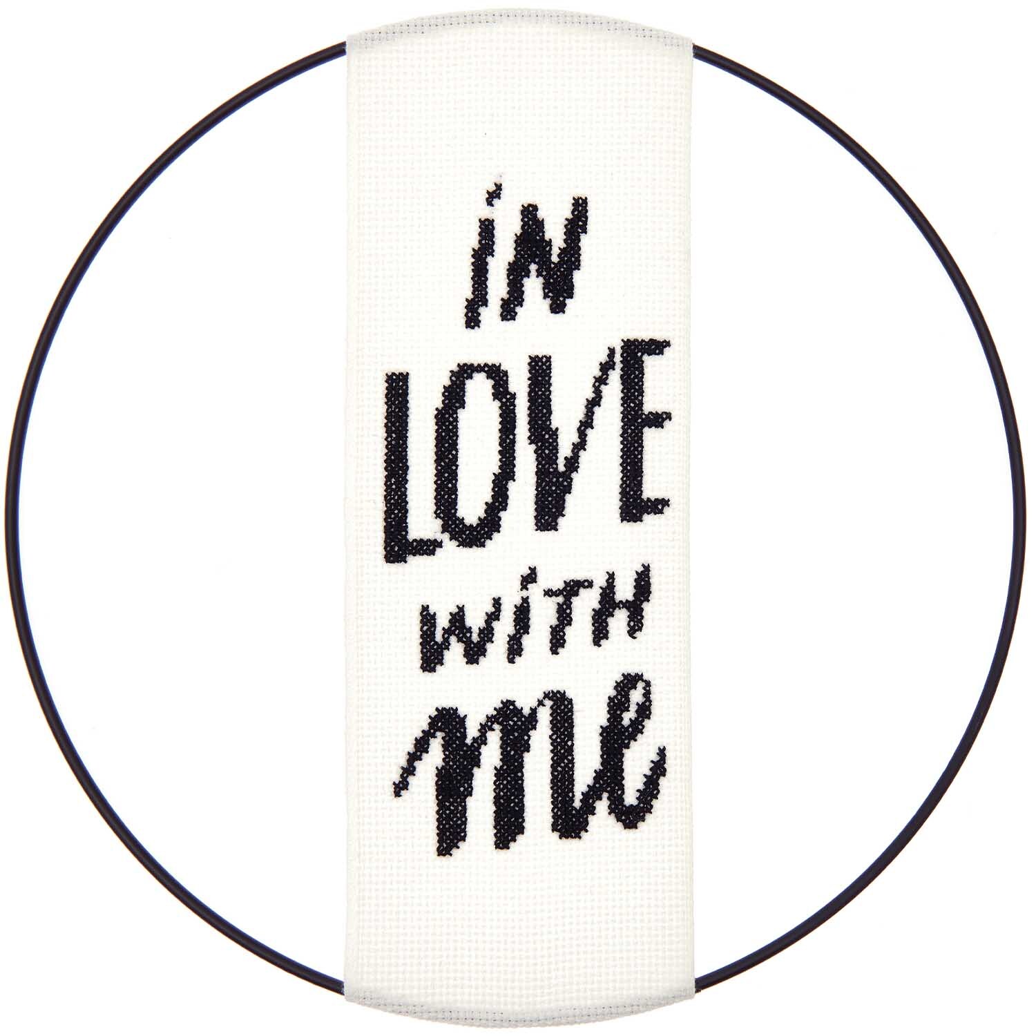 Stickpackung Band In Love With Me: Weißes Band mit schwarzem Text "in love with me" in einem runden Rahmen von Rico Design.