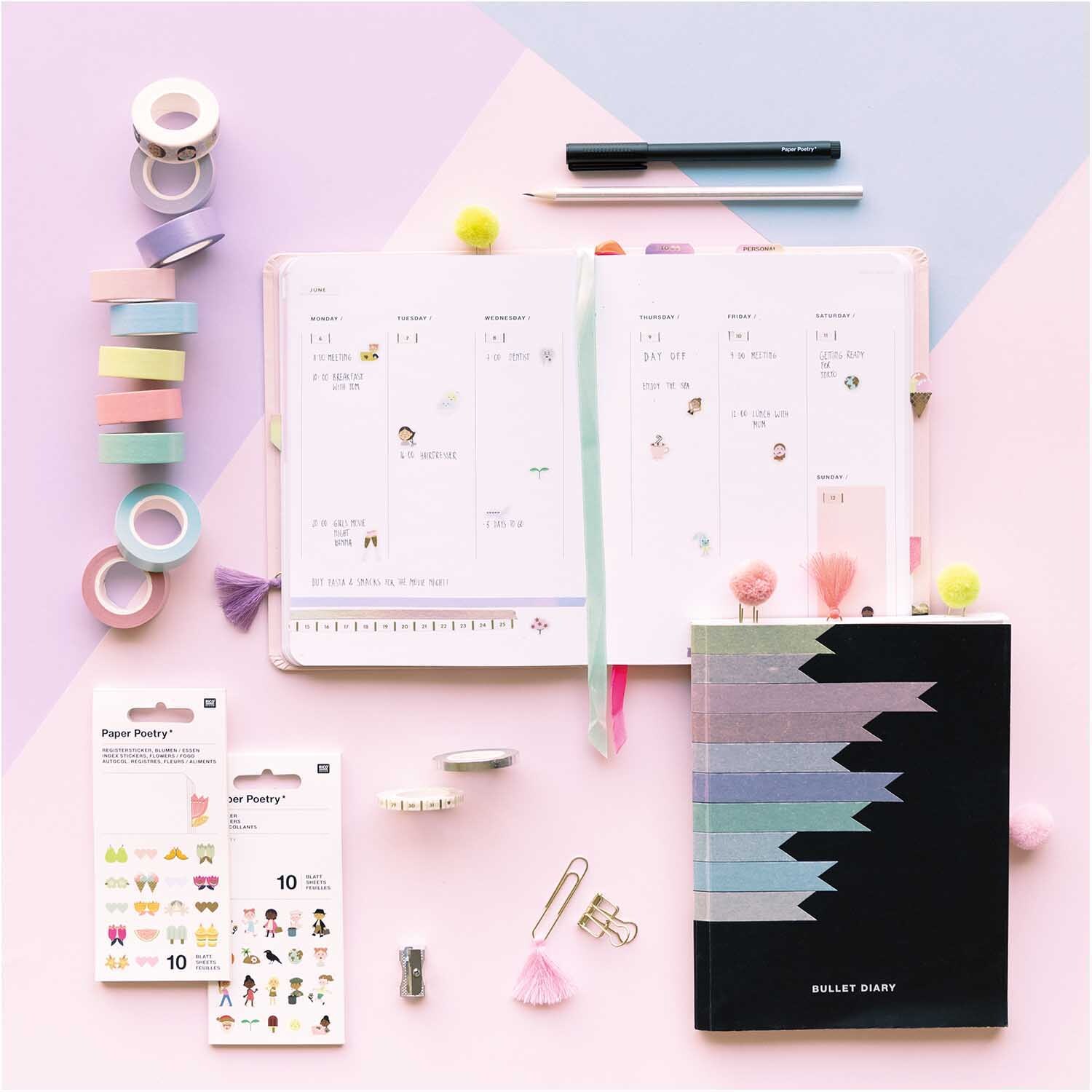 Paper Poetry Tape Set pastell 15mm 5m 10 Stück von Rico Design Paper Poetry Tape Set pastell 15mm 5m 10 Stück, mehrfarbig, neben einem geöffneten Planer und Bullet Journal auf rosa Hintergrund.